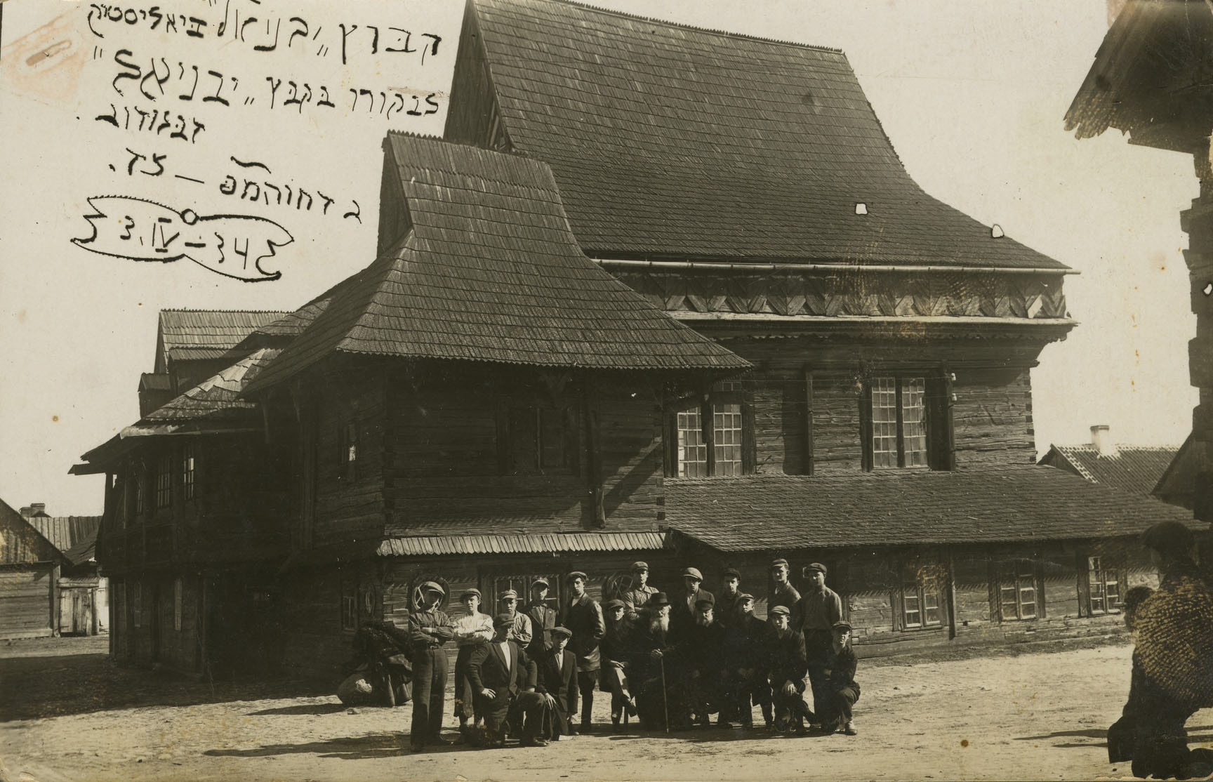 1934.04.03 | Członkowie Hechalutz Mizrachi hachshara Yavniel pozują przed drewnianą synagogą w Zabłudowie | z arch. United States Holocaust Memorial Museum