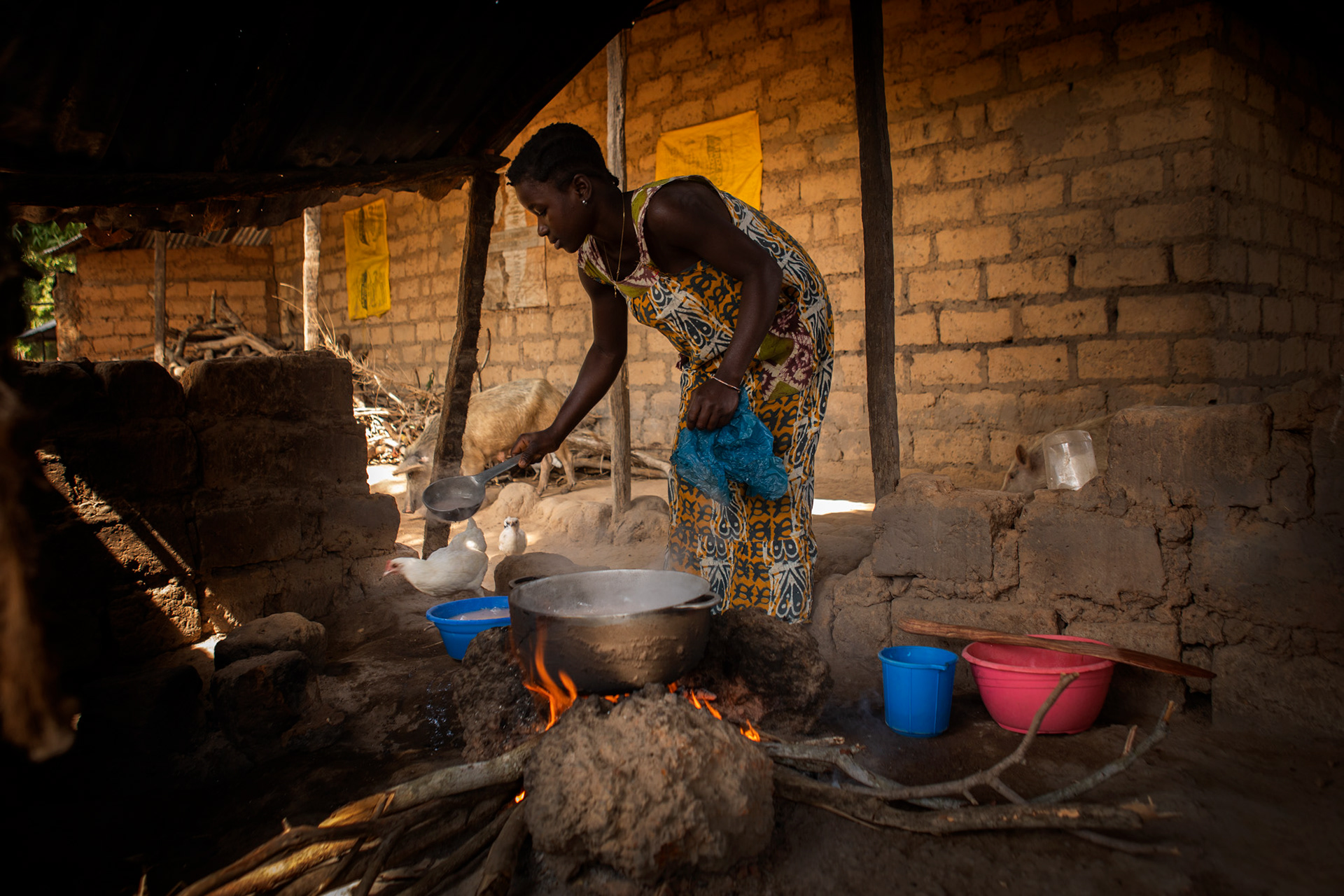 giovane donna di etnia balanta che cucina nel suo villaggio in guinea bissau, young woman cooking in her balanta village, guinea bissau, africa
