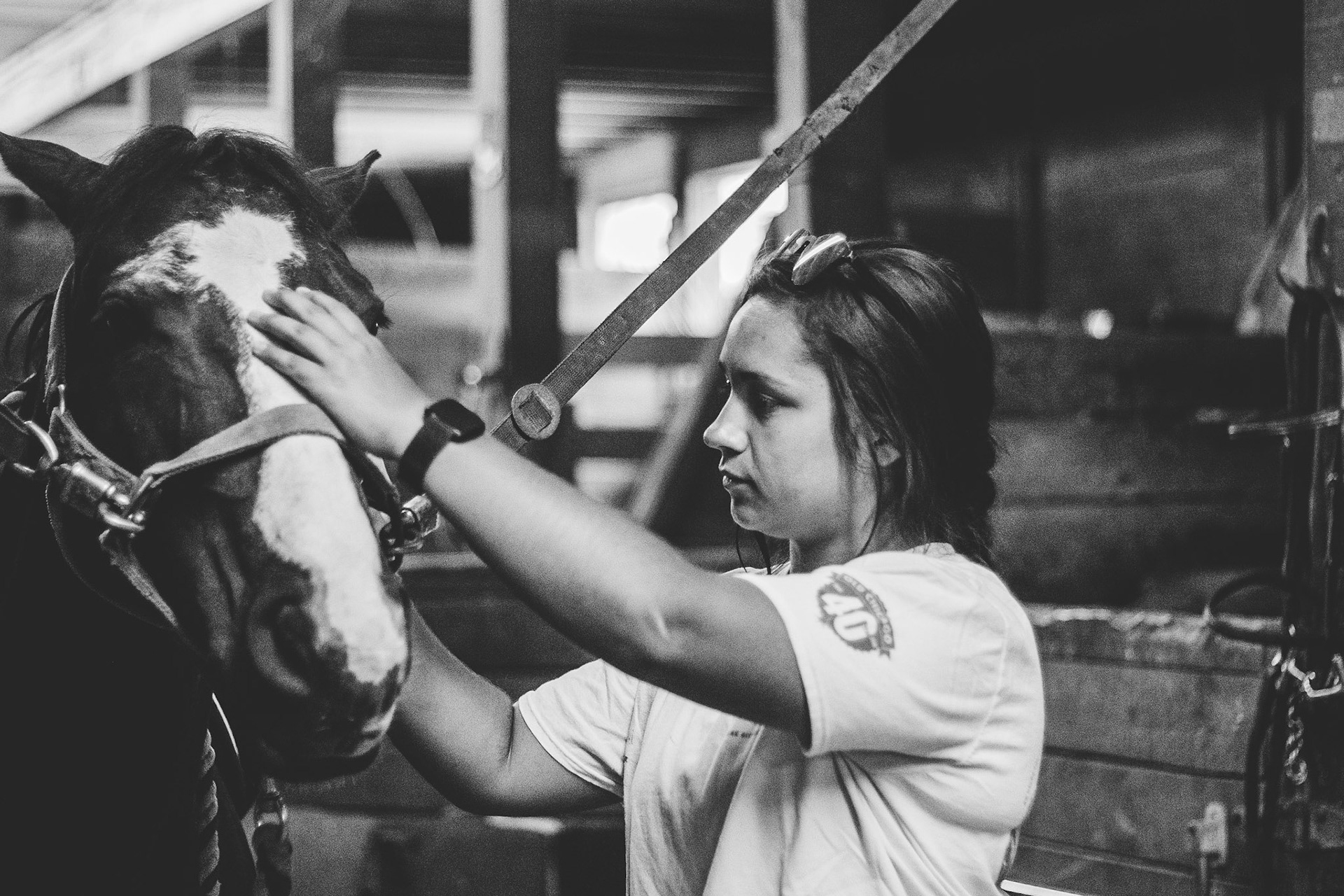 Couneslor Robyn Grace pets a horse after saddling it for a camper.  The camp has a seperate horse riding program that Grace helped to faciliate during the 2019 camp session.