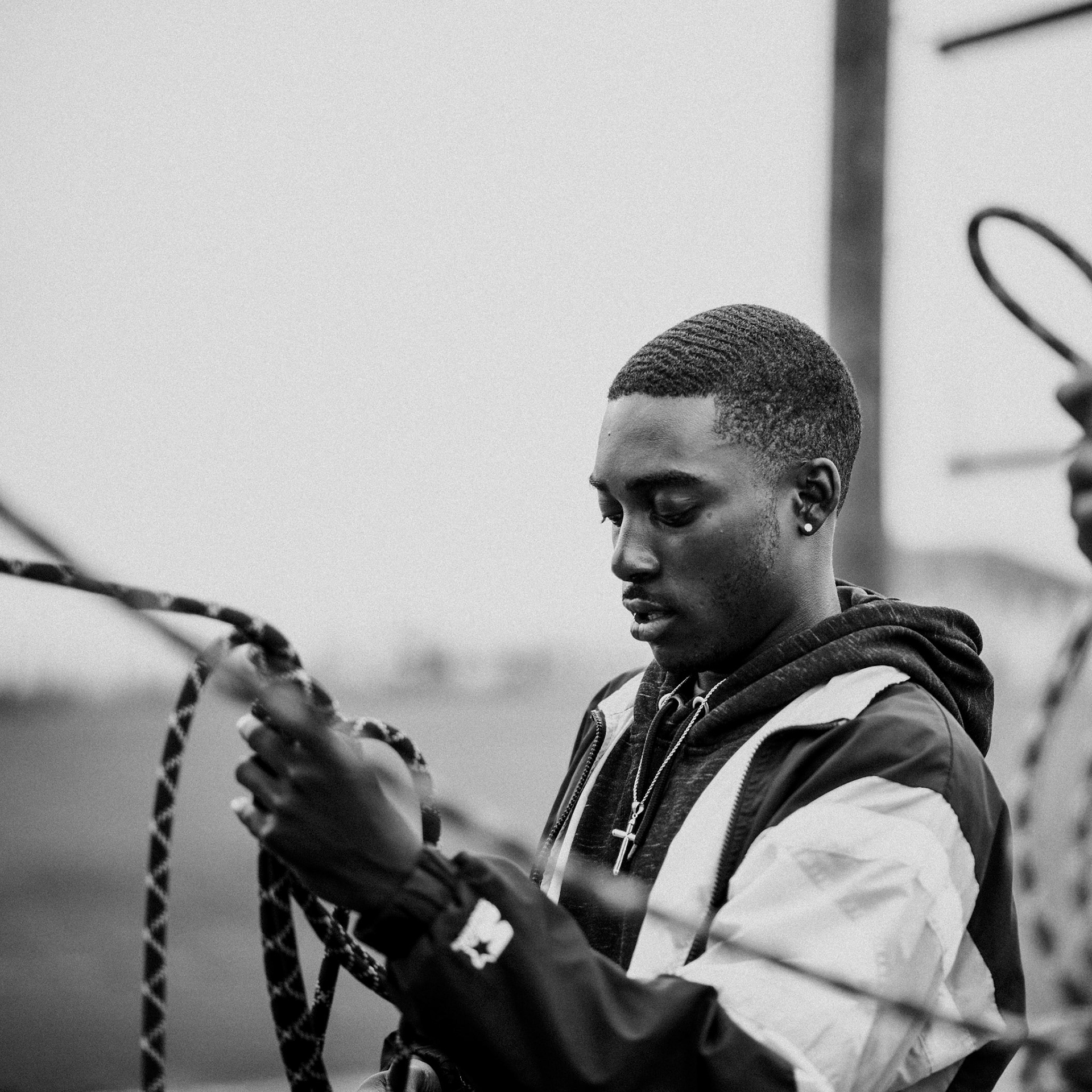 Program director Keenan ties knots to prepare the climbin wall for campers at Camp Harbor View.