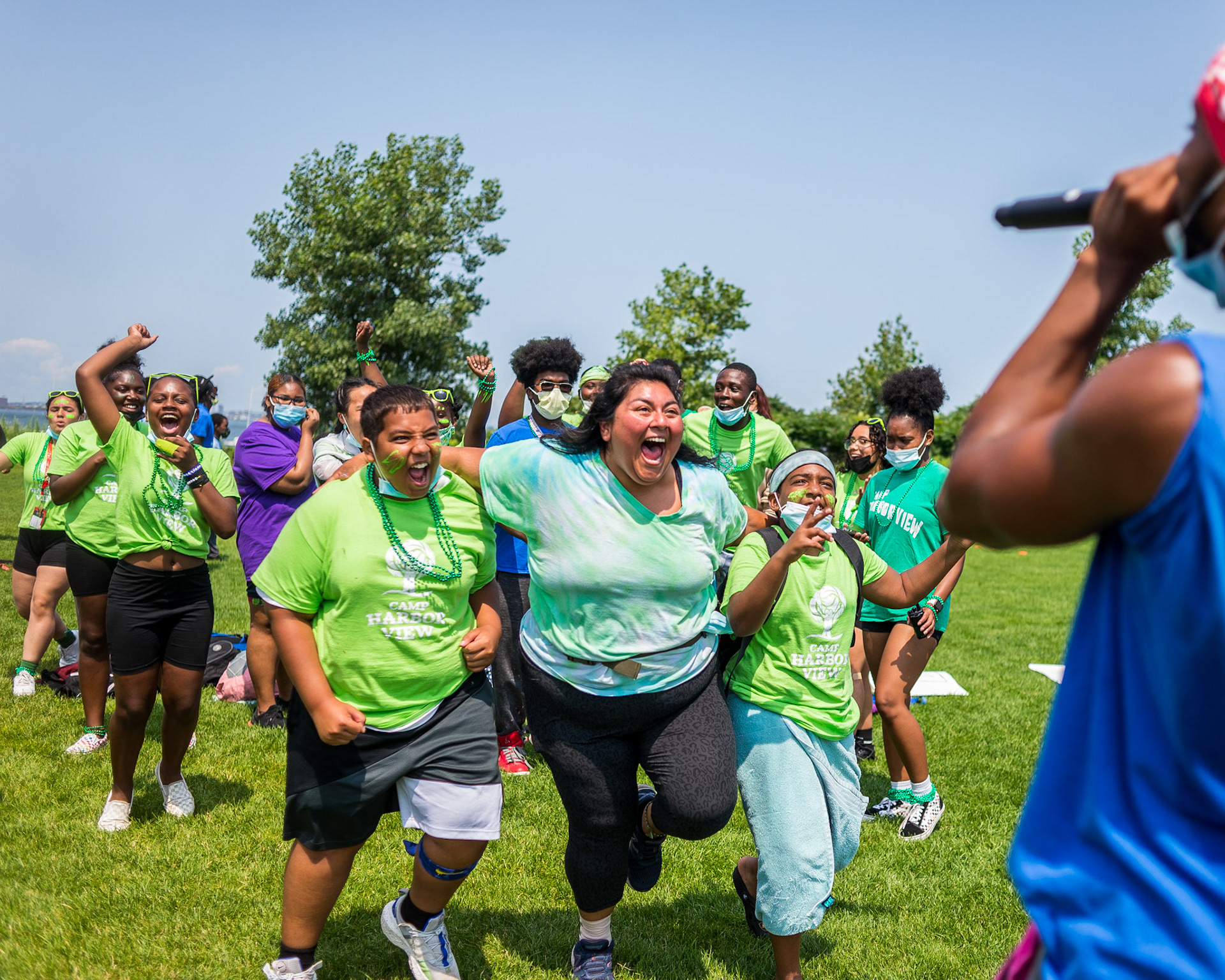 Team Leader Joanna and her campers rush to celebrate their win of the hustle-an amazing race inspired competition-at Camp Harbor View at the end of the second session.