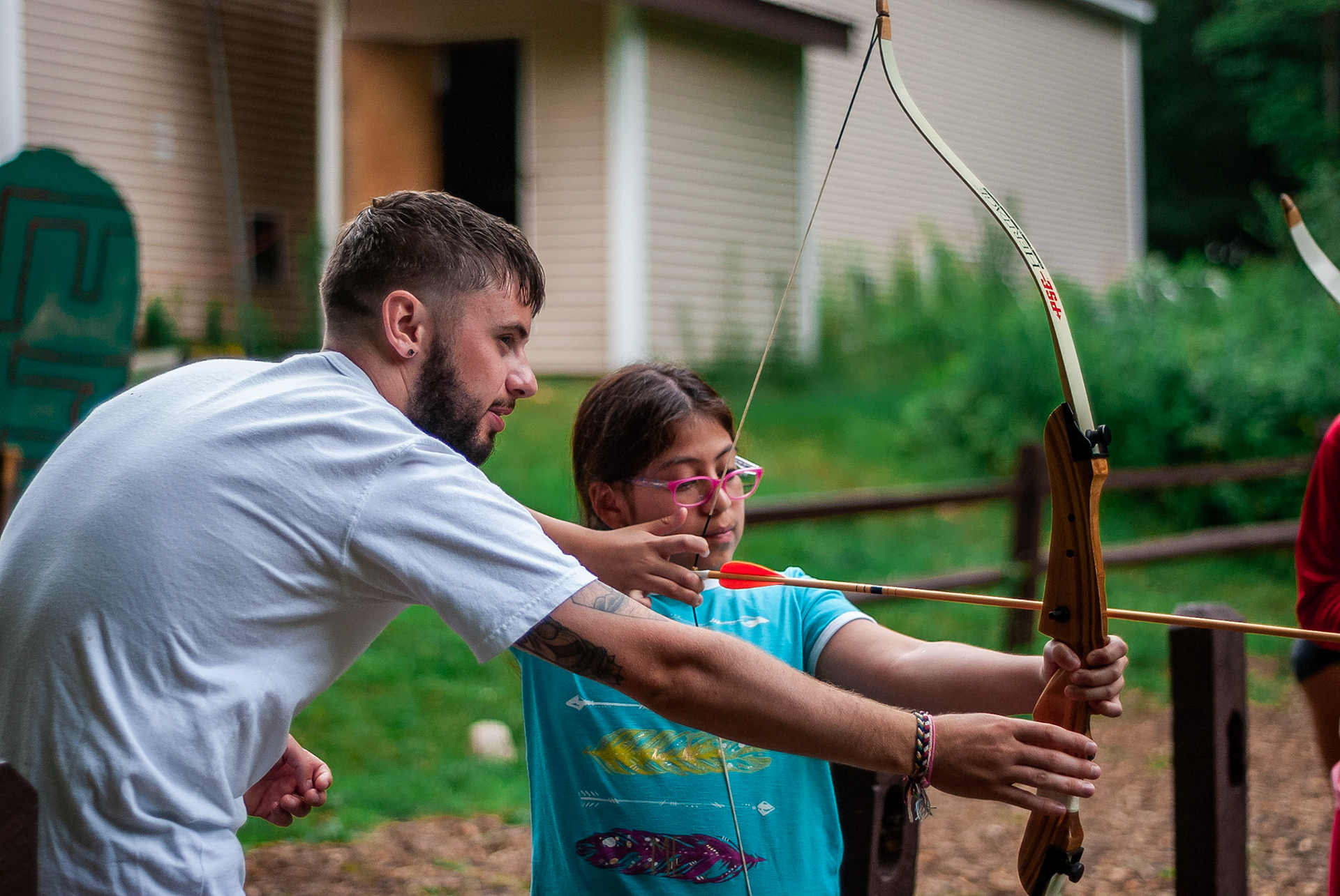 Counselor Sean helps a camper with her archery.  Sean has worked at the Hinsdale-based camp for three consective summers.  He is an Irish native and has formed a strong bond with the returning international staff.