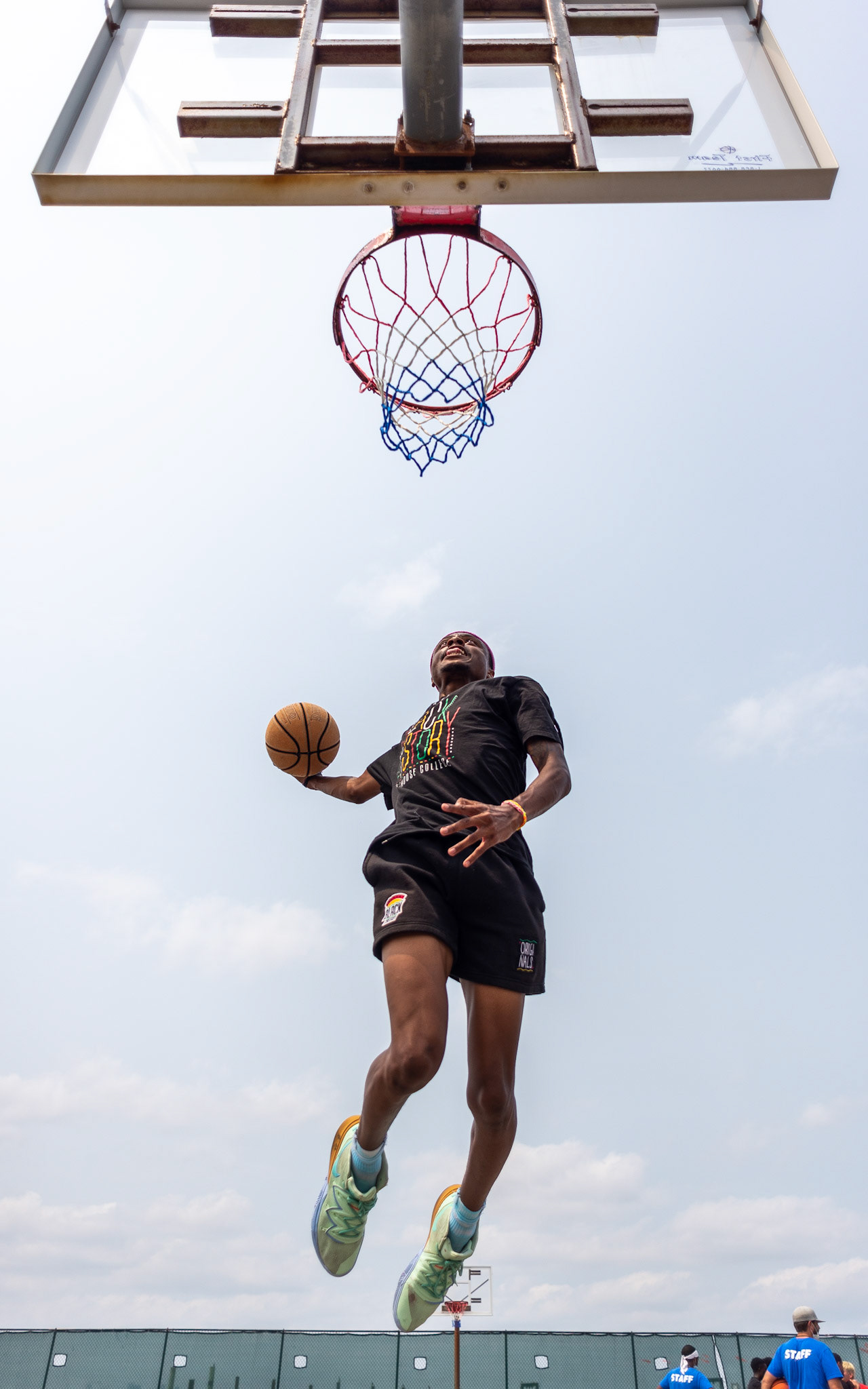 Team leader Jakai jumps to dunk after the Camp Harbor View staff basketball game.