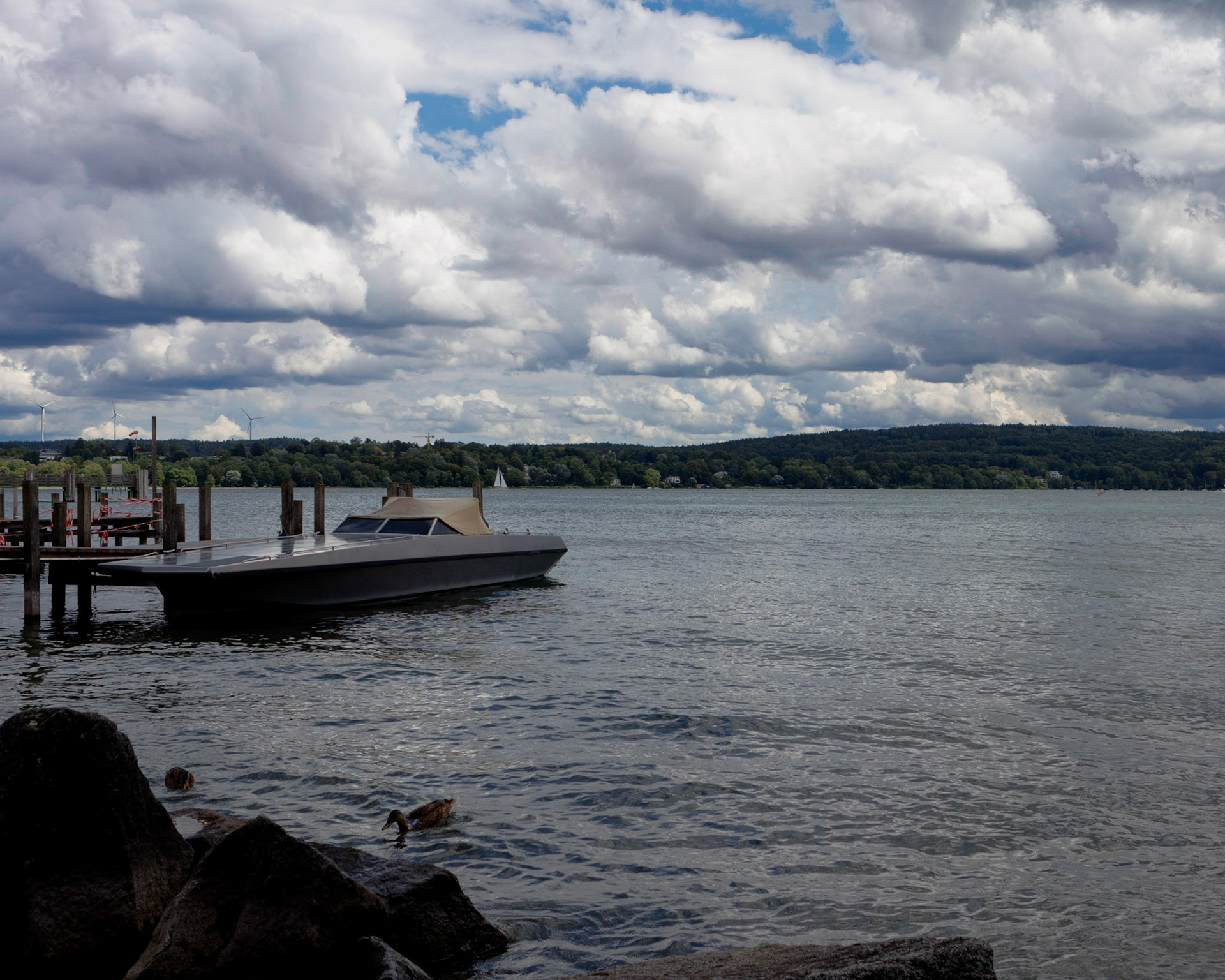 Docked boat in the Starnbergersee under cloudy summer skies