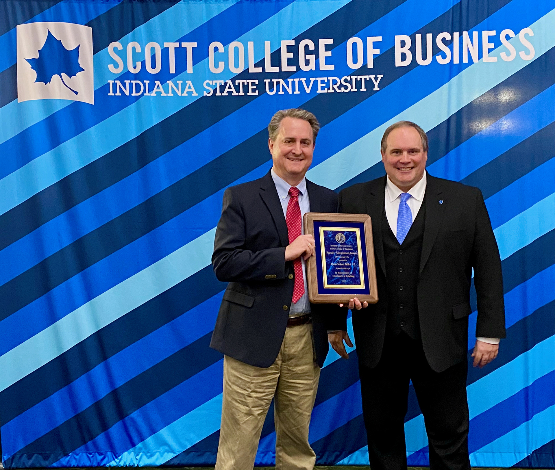 Matt Cohen, Senior Instructor of Finance, receiving his College Teaching Award from dean Terry Daugherty. April 22, 2022