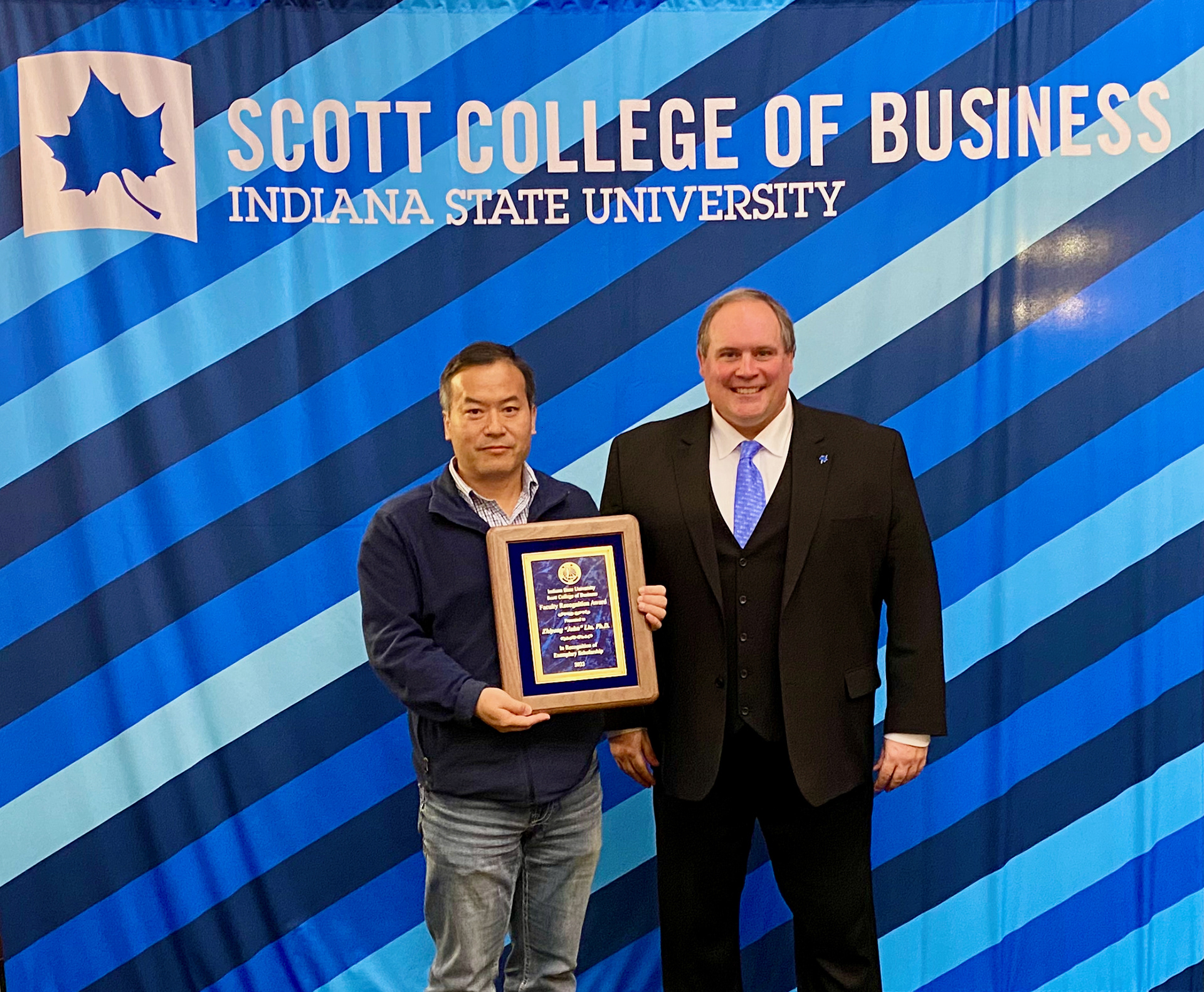 John Liu, Professor of Insurance & Risk Management, receiving his College Scholarship/Research Award from dean Terry Daugherty. April 22, 2022