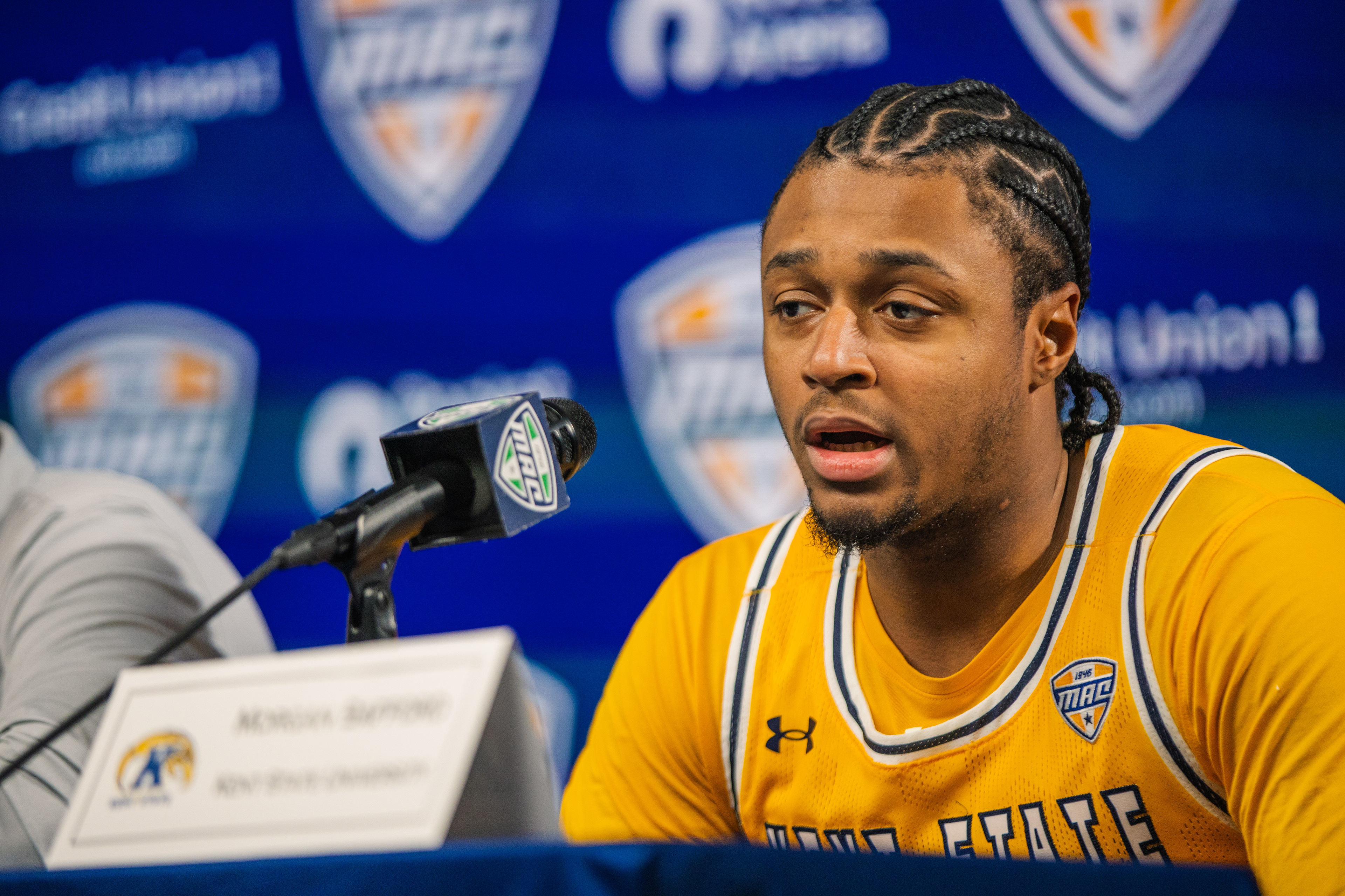 A Kent State guard addresses the media at the post-game MAC Tournament press conference, reflecting on a season that carried the Flashes to the conference's biggest stage.