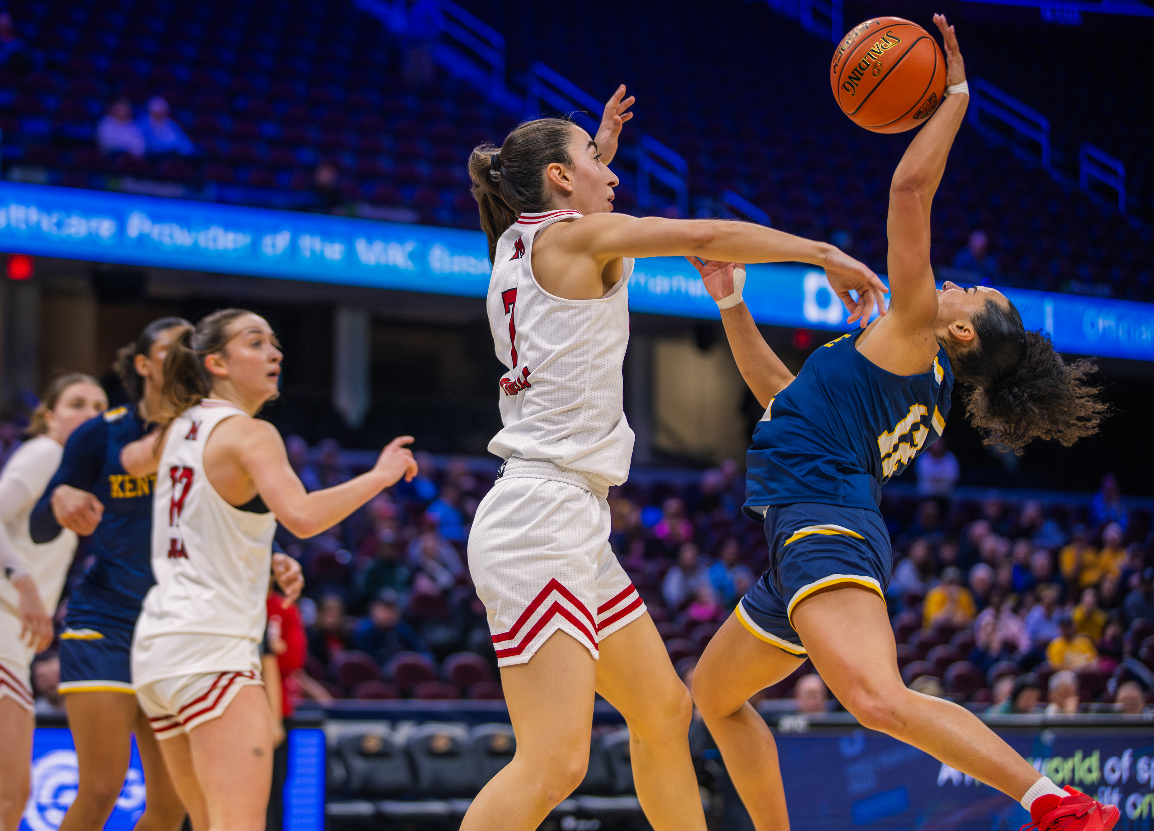 A Miami (OH) defender contests hard at the rim as Kent State's guard fights through contact during the MAC Tournament quarterfinals at Rocket Mortgage FieldHouse.