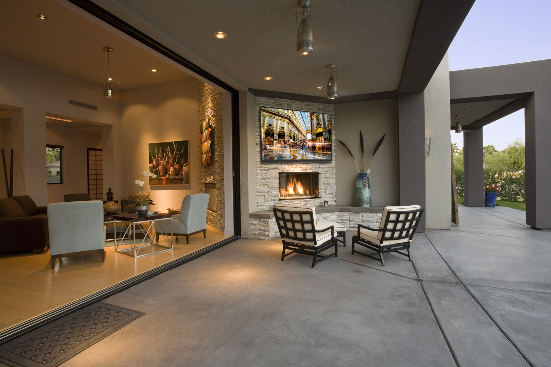 View of chairs by fireplace in patio of a modern home