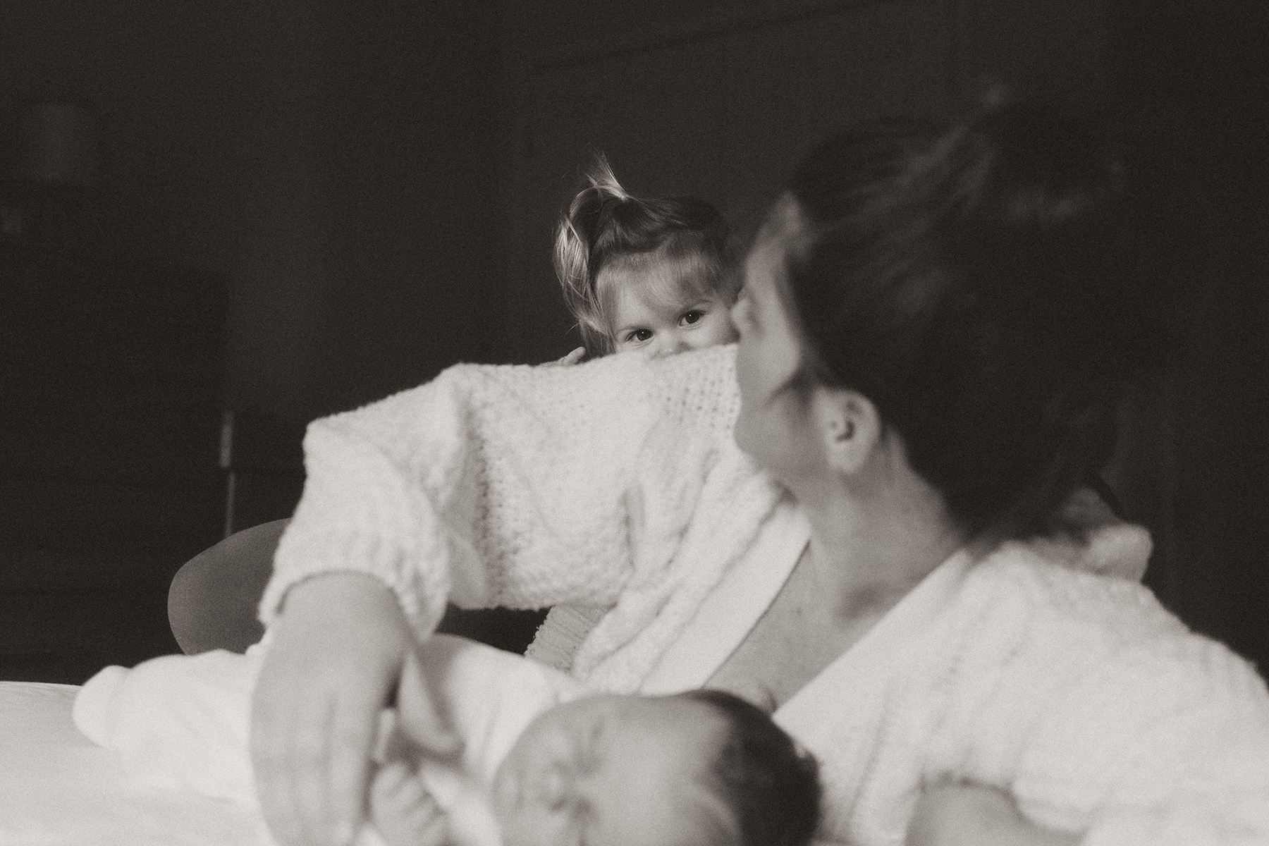 daughter peeping over mother's shoulder