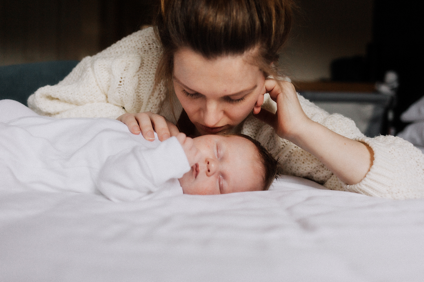 mother snuggling with newborn baby