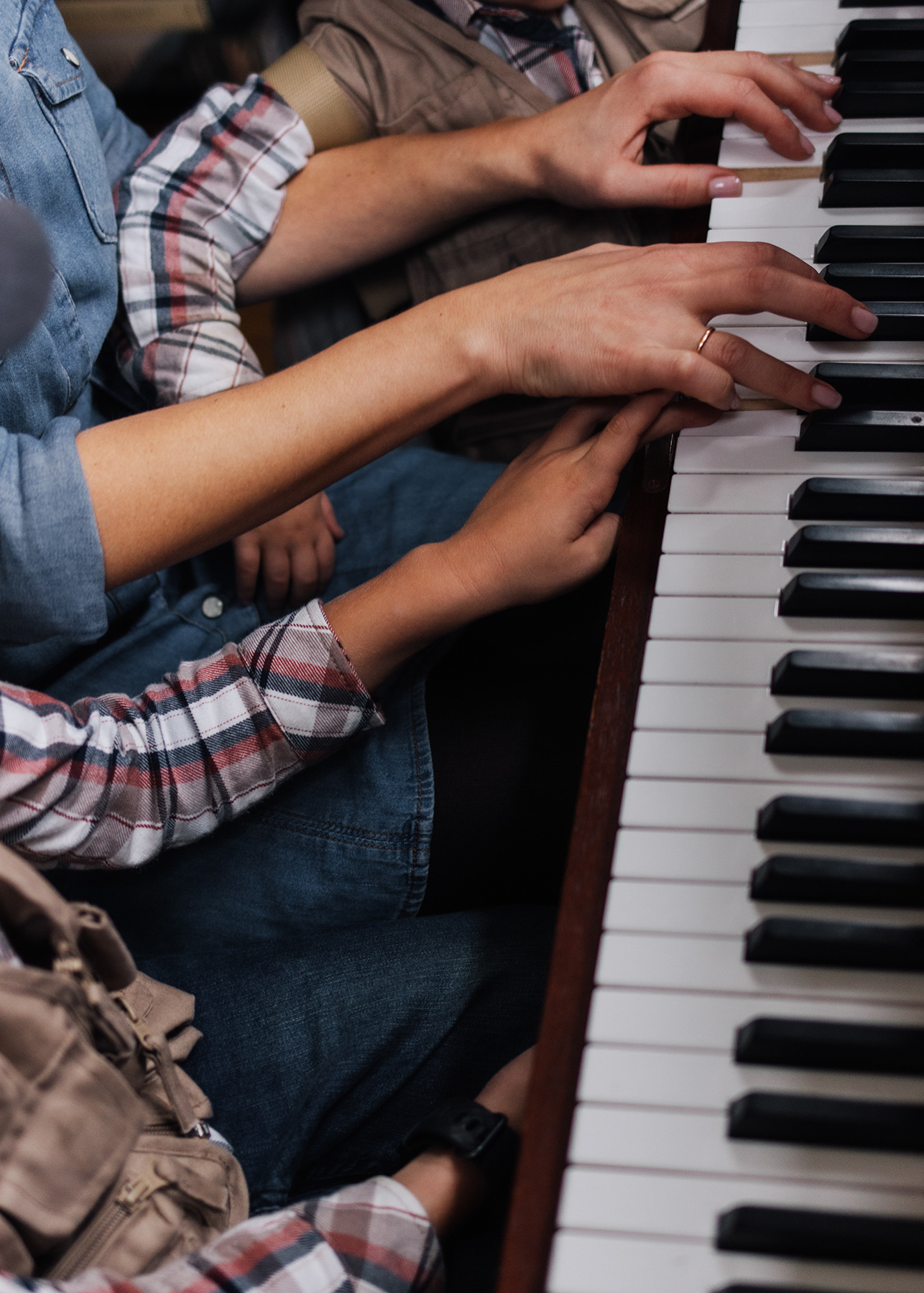 mother playing piano with sons