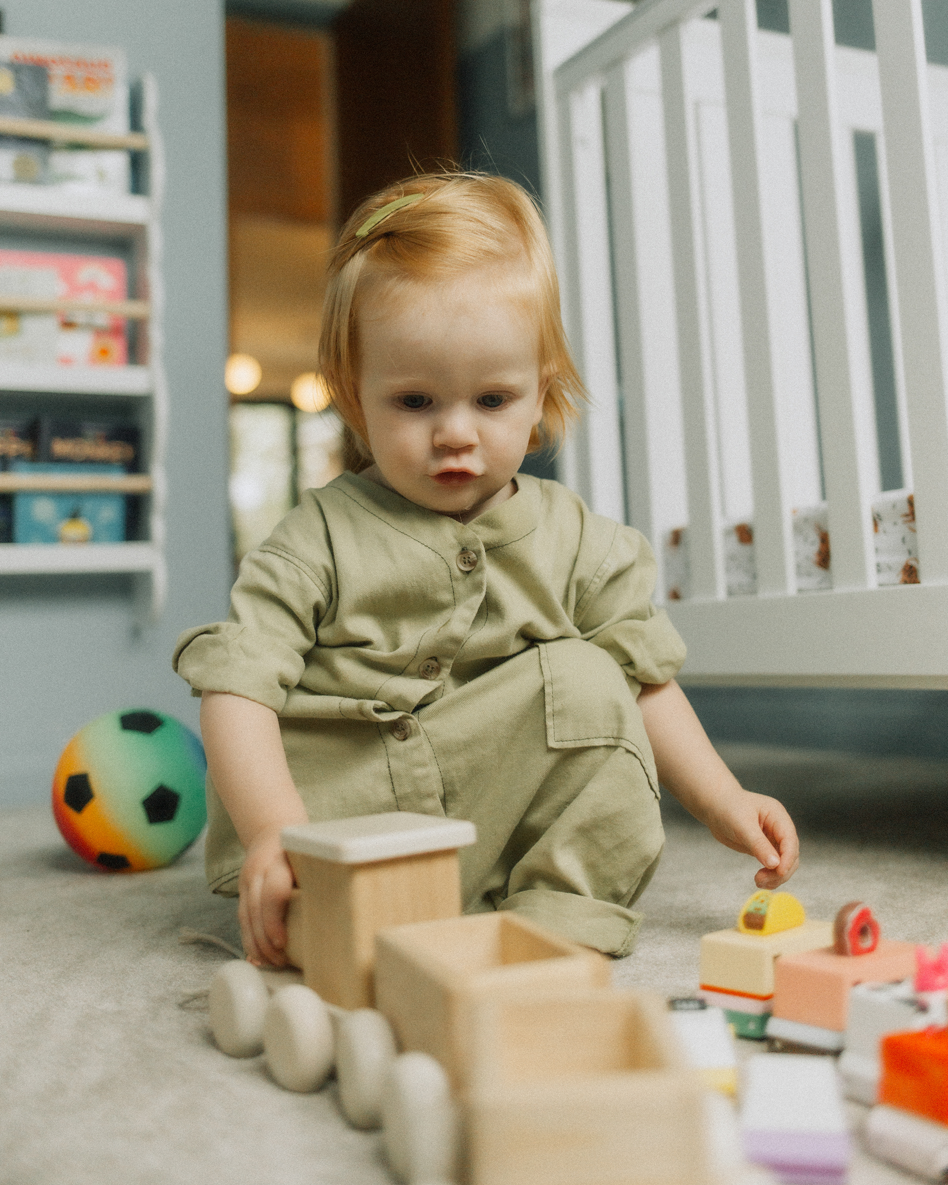 little boy playing with wooden toy train