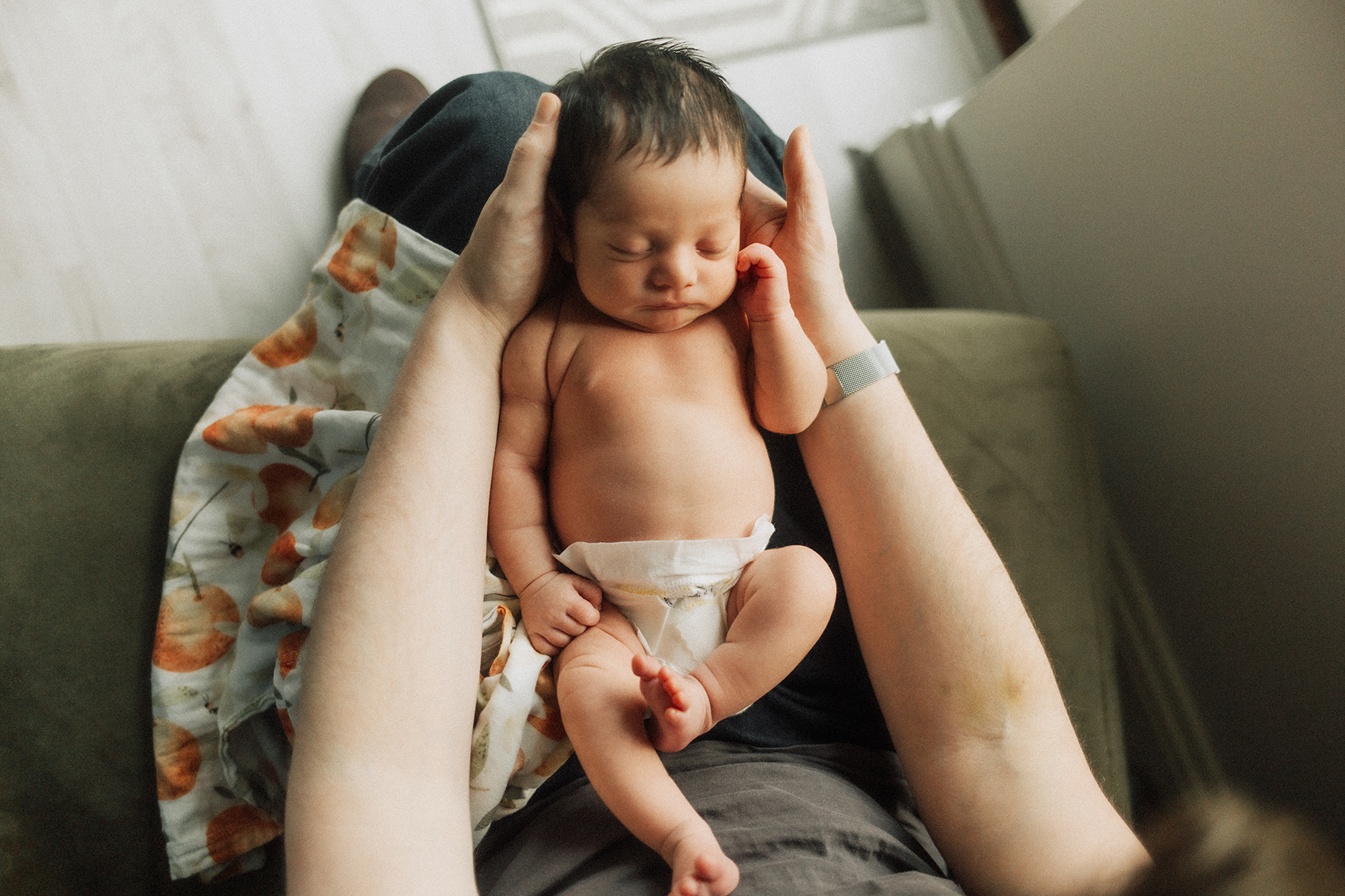 newborn baby on daddy's lap