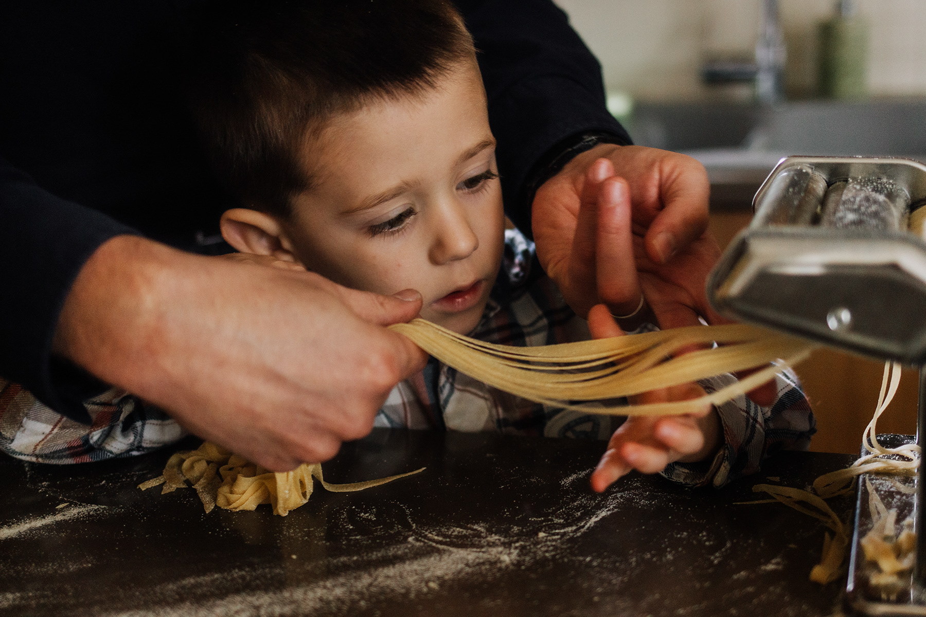 boy looking at pasta being turned out