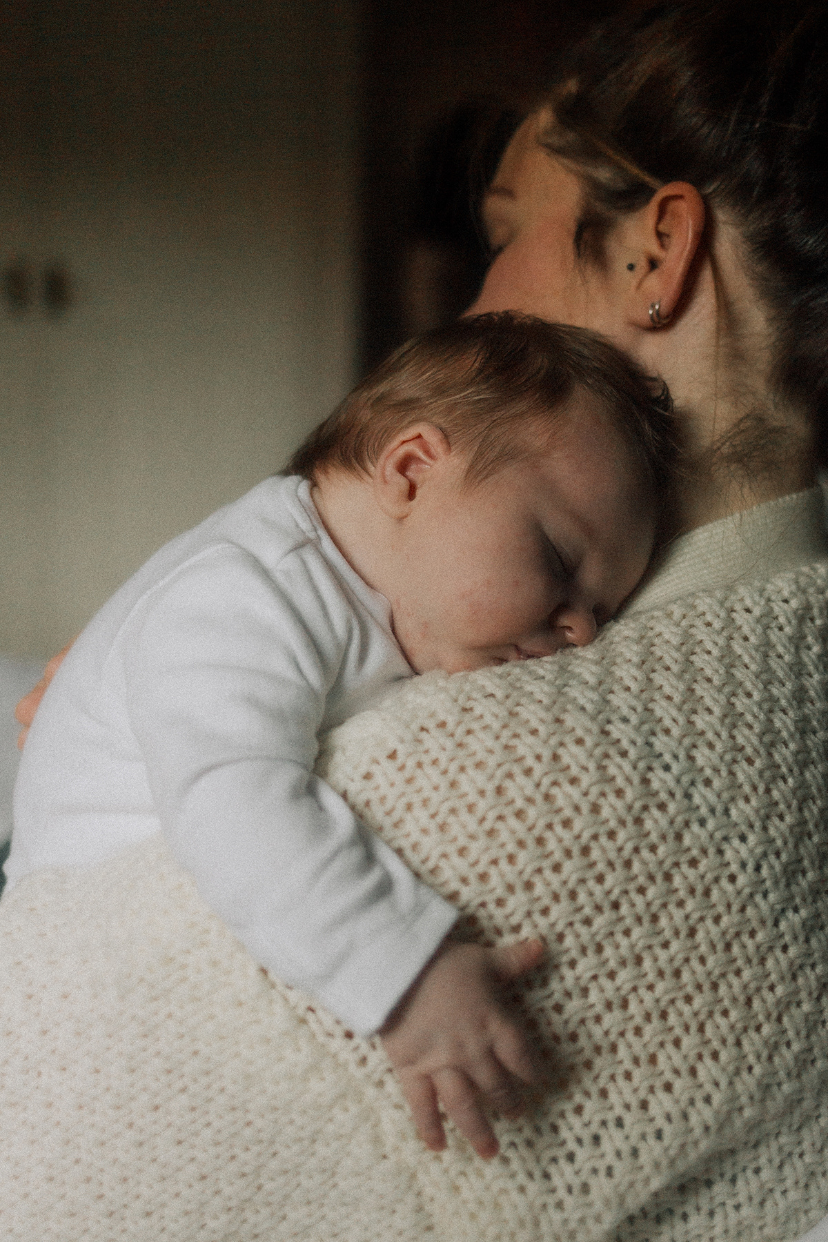 baby sleeping on mother's shoulder
