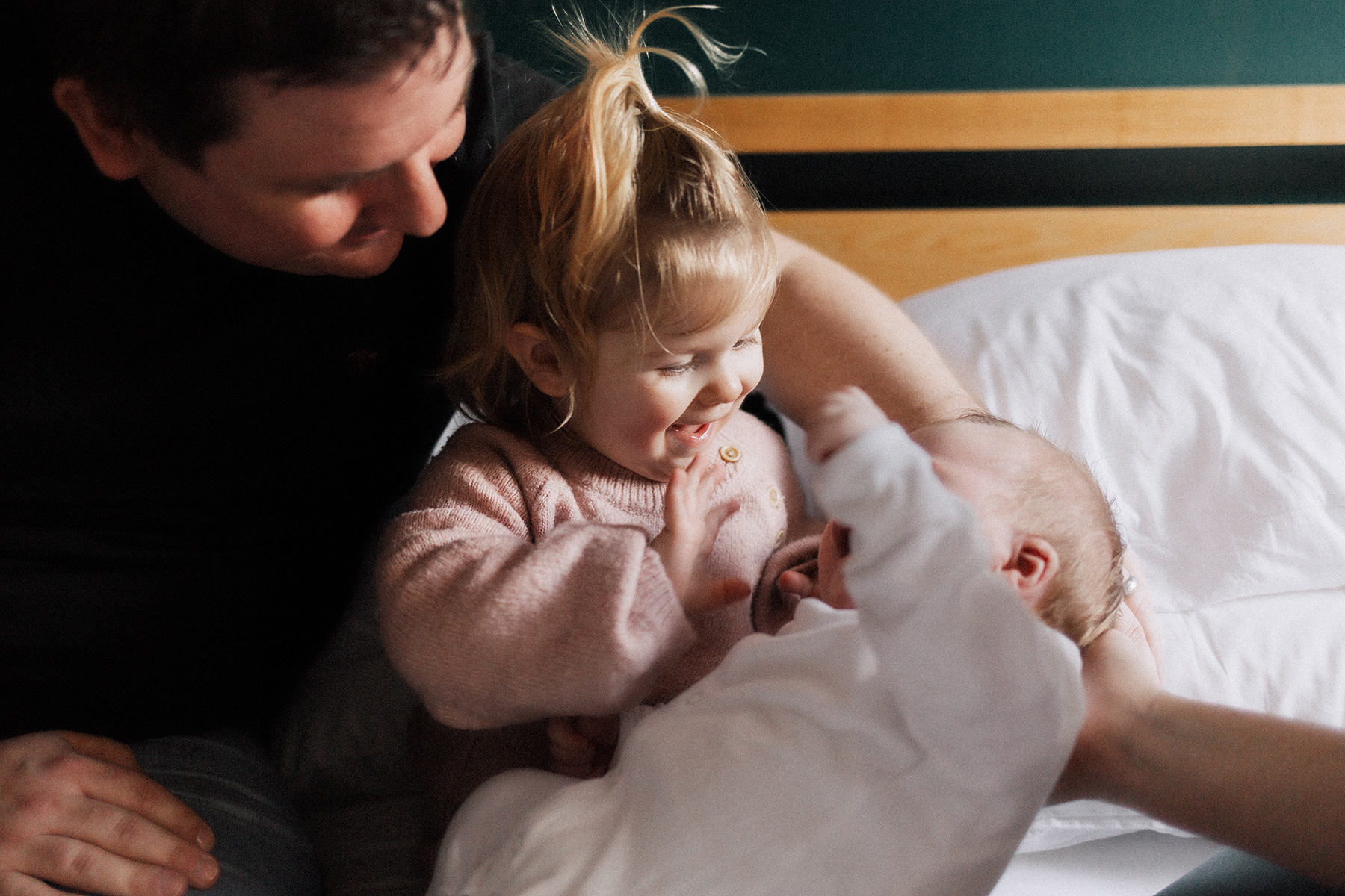 big sister waving hello to baby brother