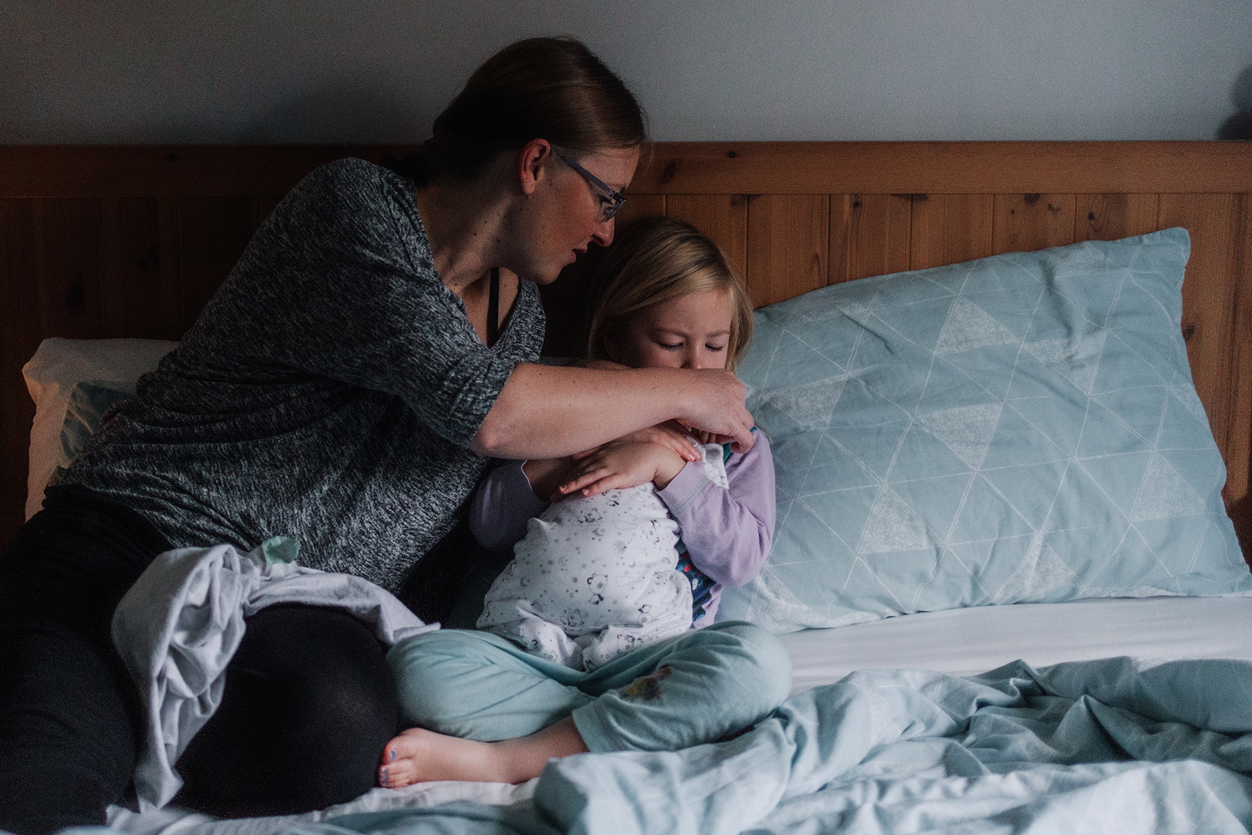mom and daughter cuddling baby