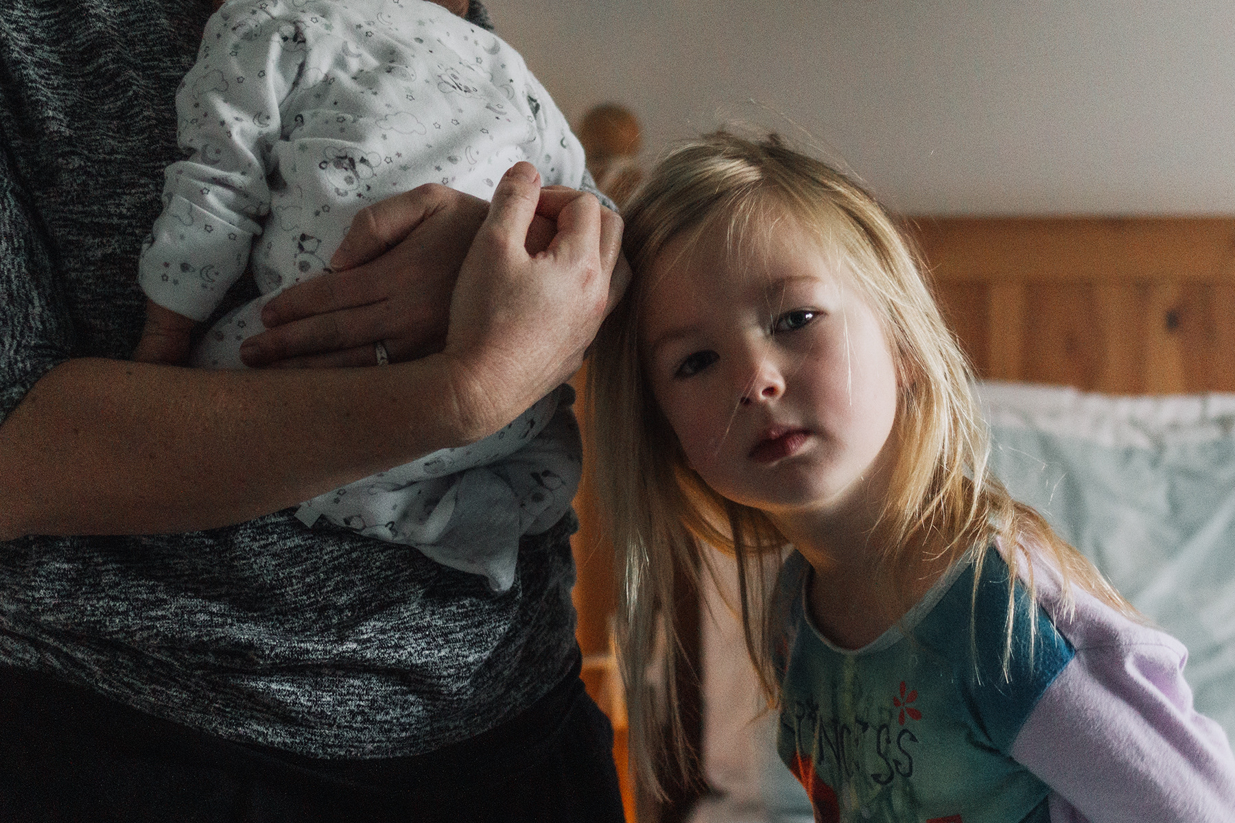 little girl resting her head on her mom's hands