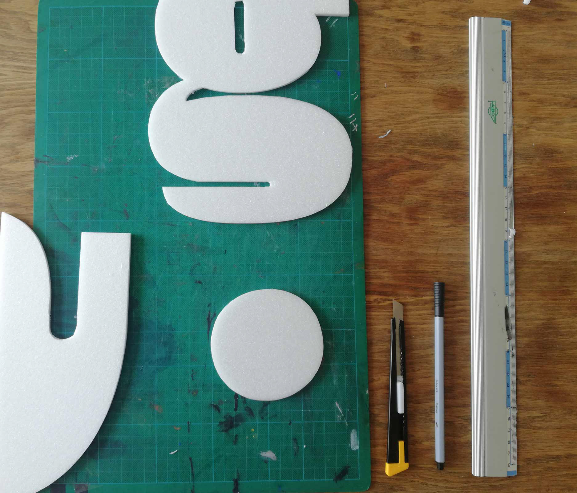 Prozessbilder: Typografische Experimente mit handgeschnittenen Buchstaben. Abstraktion der Buchstaben. 