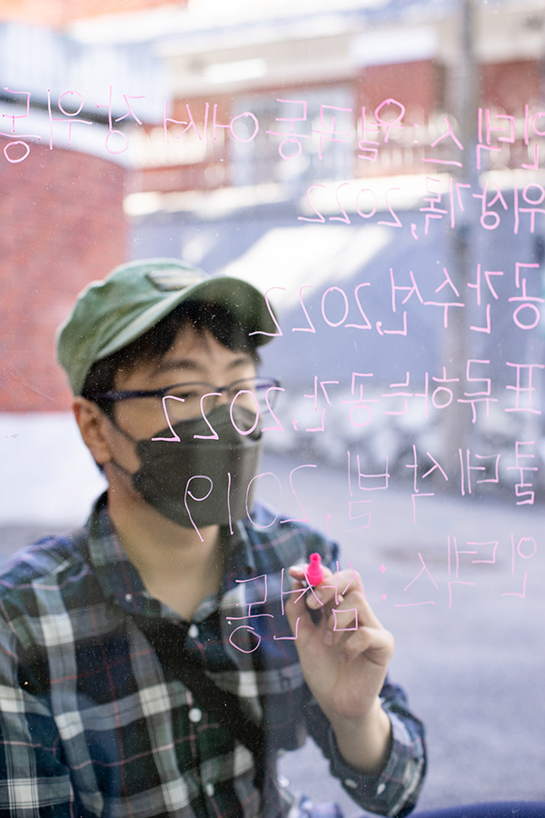 Sungho Shin 신승호, handwritten show titles on the window, Topological Space, 2022