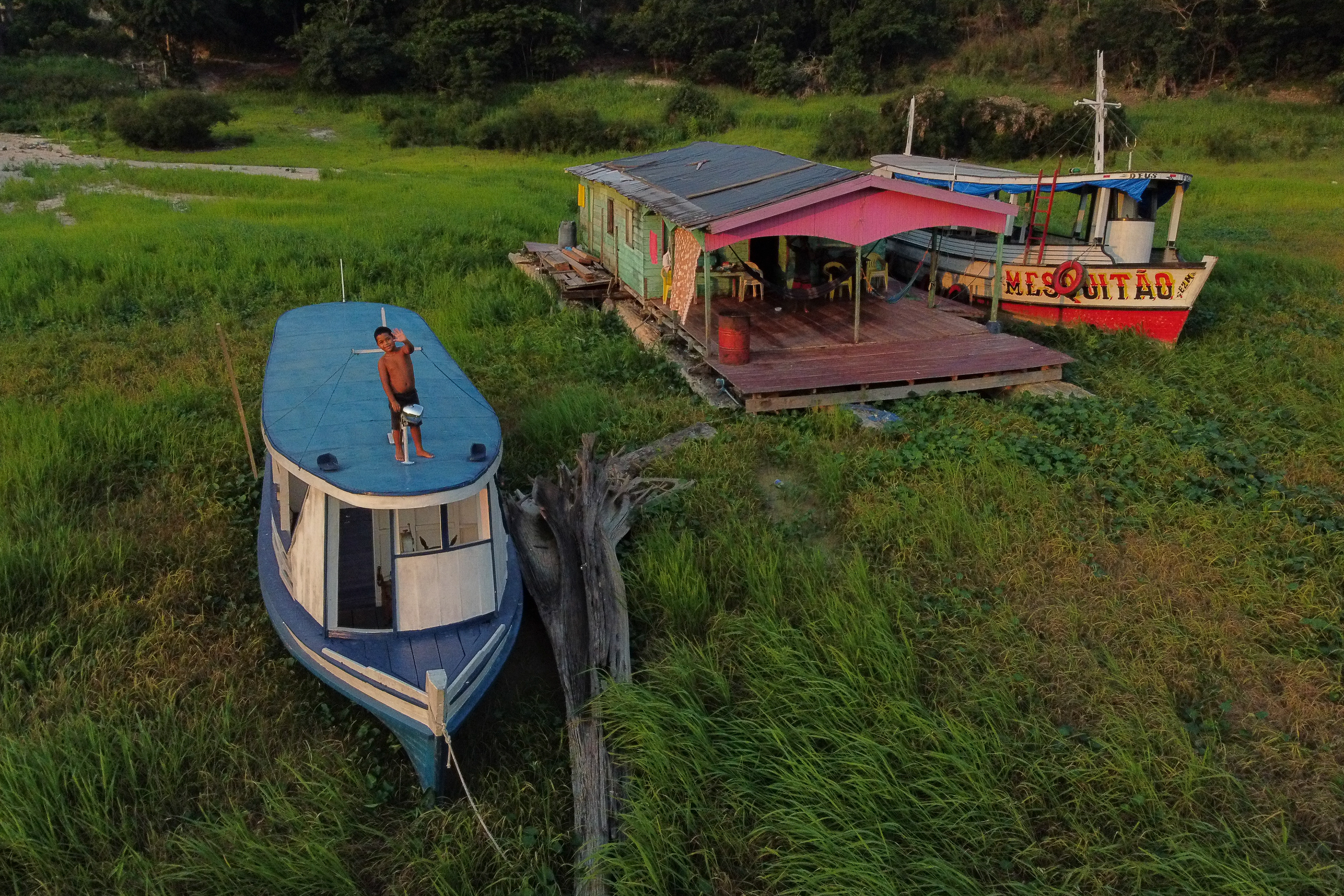 During the worst drought in over 100 years in the state of Amazonas in 2024, the image of a boy waving at a drone caught the attention. He was standing on a stranded boat next to a floating house that was also stuck due to the drought. The photo was a finalist in the 2025 edition of Photography4Humanity, one of the largest photography contests on climate issues today. Photo: AGIF/Suamy Beydoun