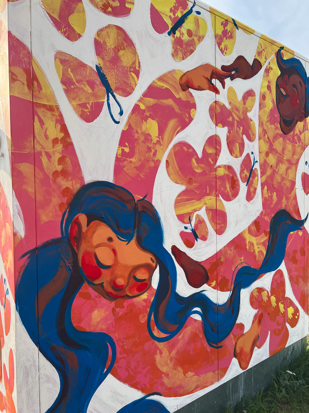 Close-up of two dancers holding hands among flowers and butterflies.