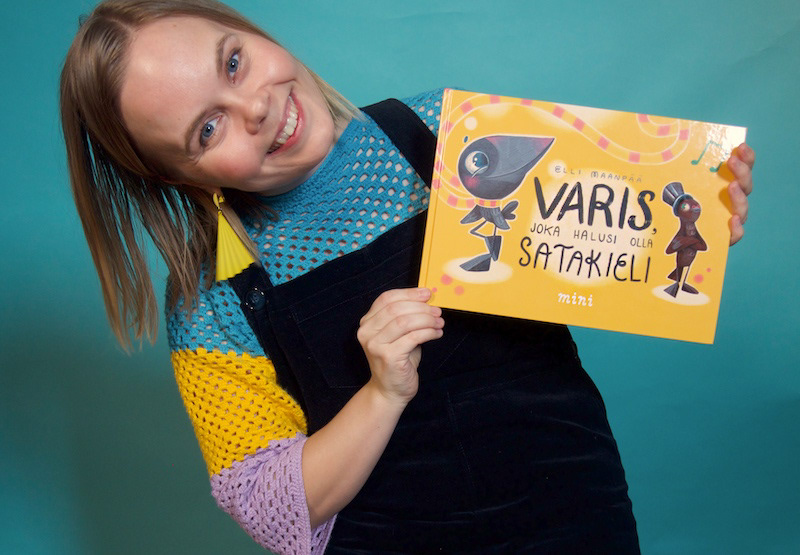 Elli Maanpää, author and illustrator, proudly holds he cute picture book at the book launch party in Oodi Helsinki.