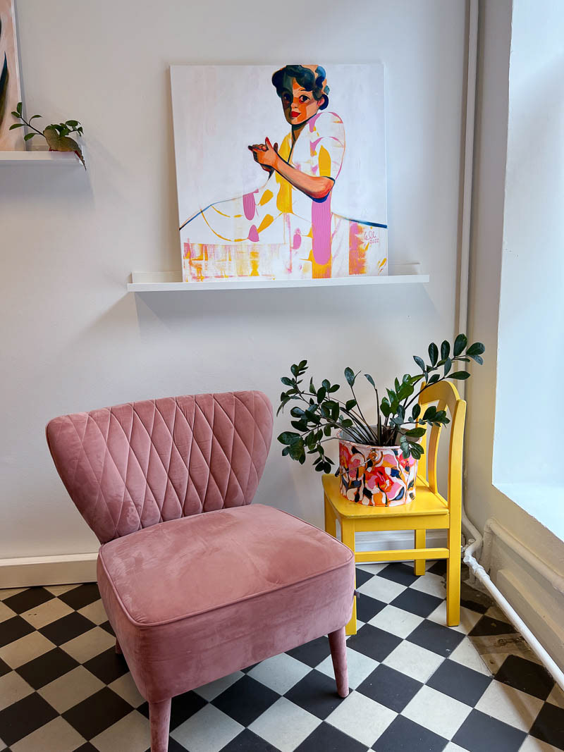 'Grandmother' painting by Elli Maanpää in a charming room with pink sofa.