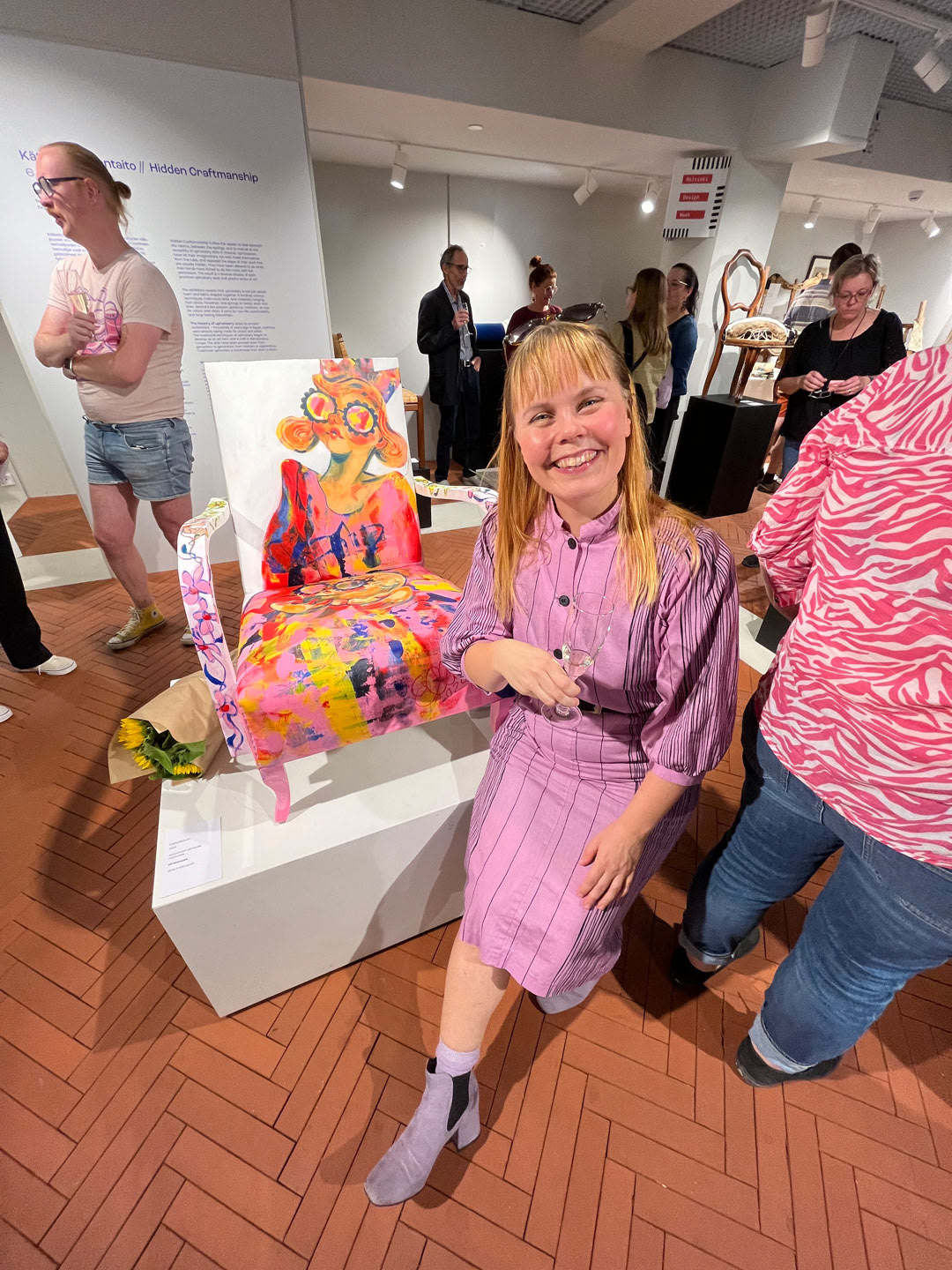 Elli Maanpää poses in front of her artwork, Throne, during the Hidden Craftsmanship exhibition vernissage. This photograph was taken by Herra Kuula.