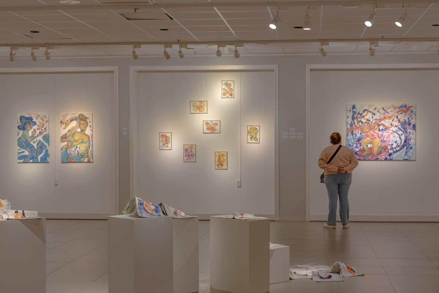 An exhibition visitor experiencing Elli Maanpää's expressive acrylic painting "Free as a bird" during the "Taivas Maanpäällä" solo show at Galleria Ars Pori. Photograph by Iiris Hellsten.