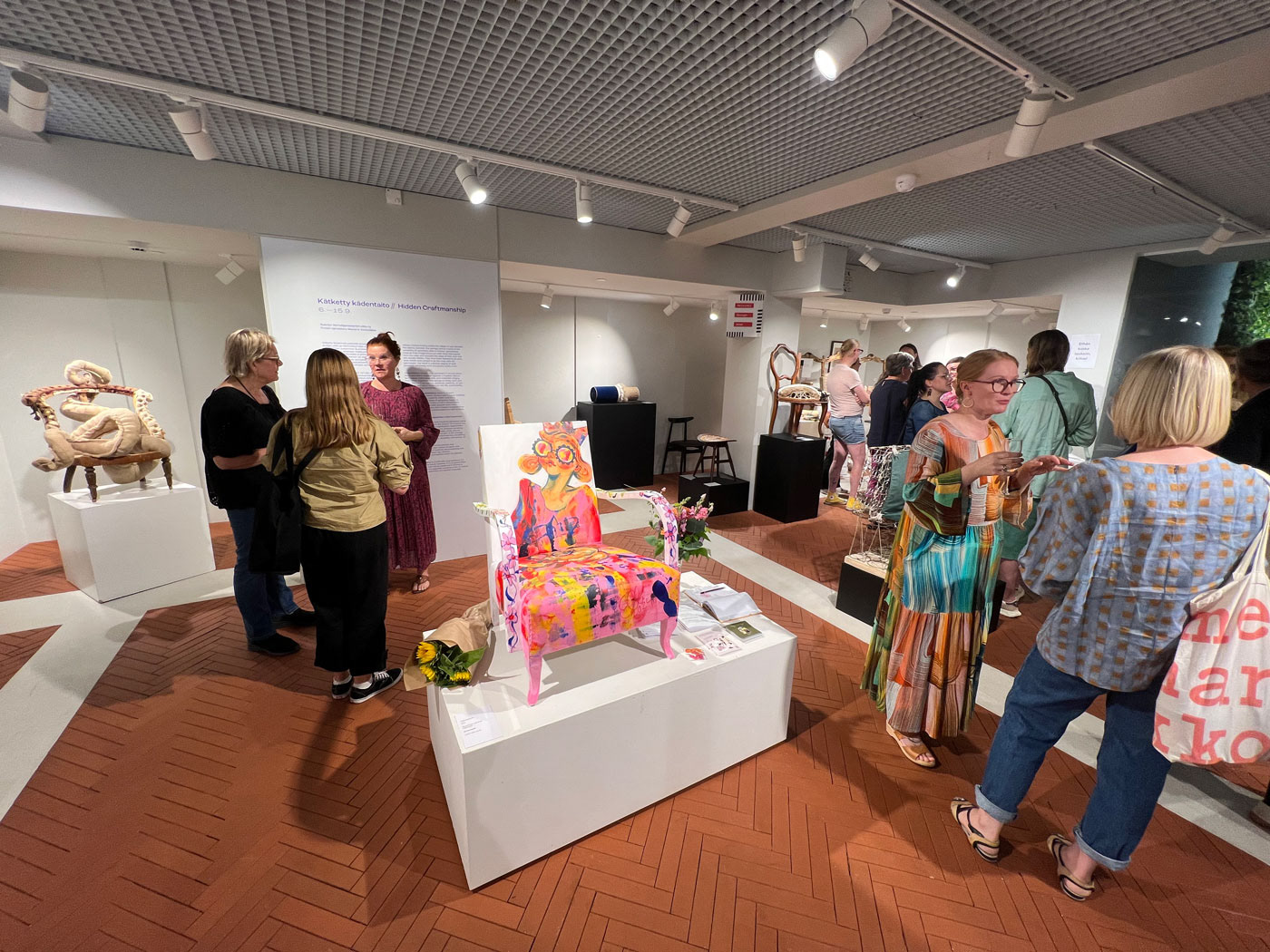 Photograph from the Hidden Craftsmanship exhibition captures the gallery space on opening evening, filled with guests and artists.