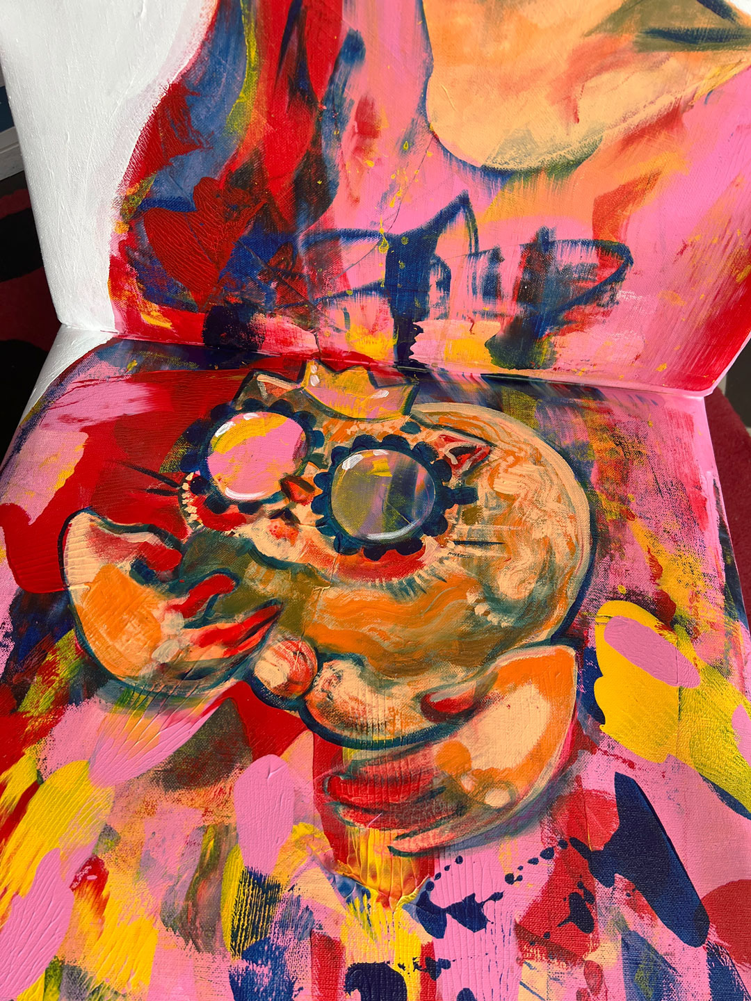 A close-up of the cat from Elli Maanpää's painted armchair, Throne, capturing the playful expression that showcases its role as the true ruler of the seat.
