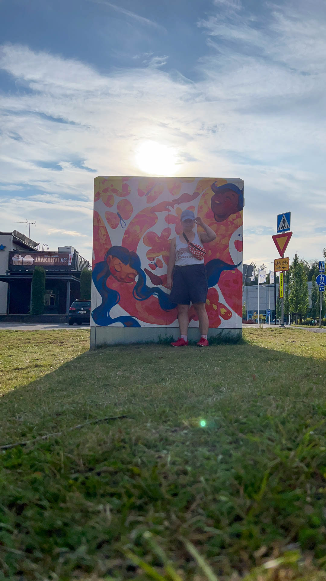 Elli Maanpää posing in front of the finished piece after a 10-hour painting session.