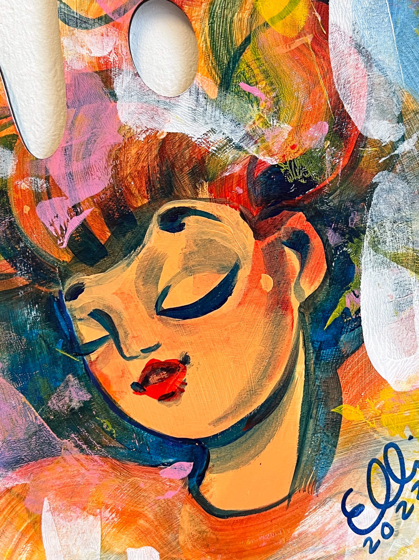 Colors swirl around woman's closed eyes.