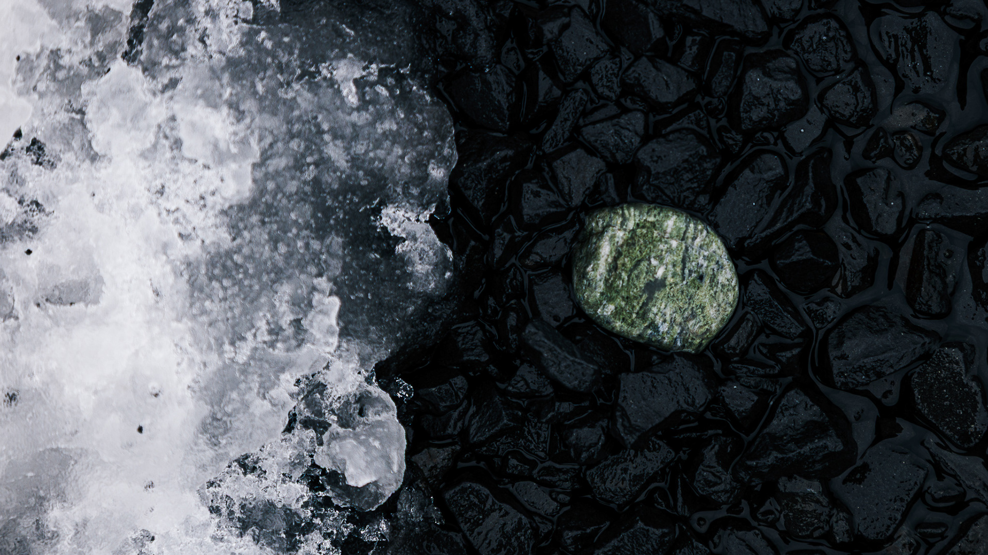 Macro of the detail in a green banded stone black gravel and white snowand ice