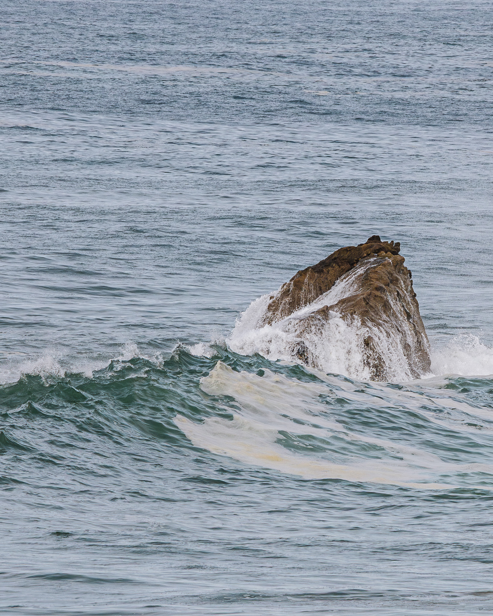 Wave Crashing over a rock in the pacific ocean