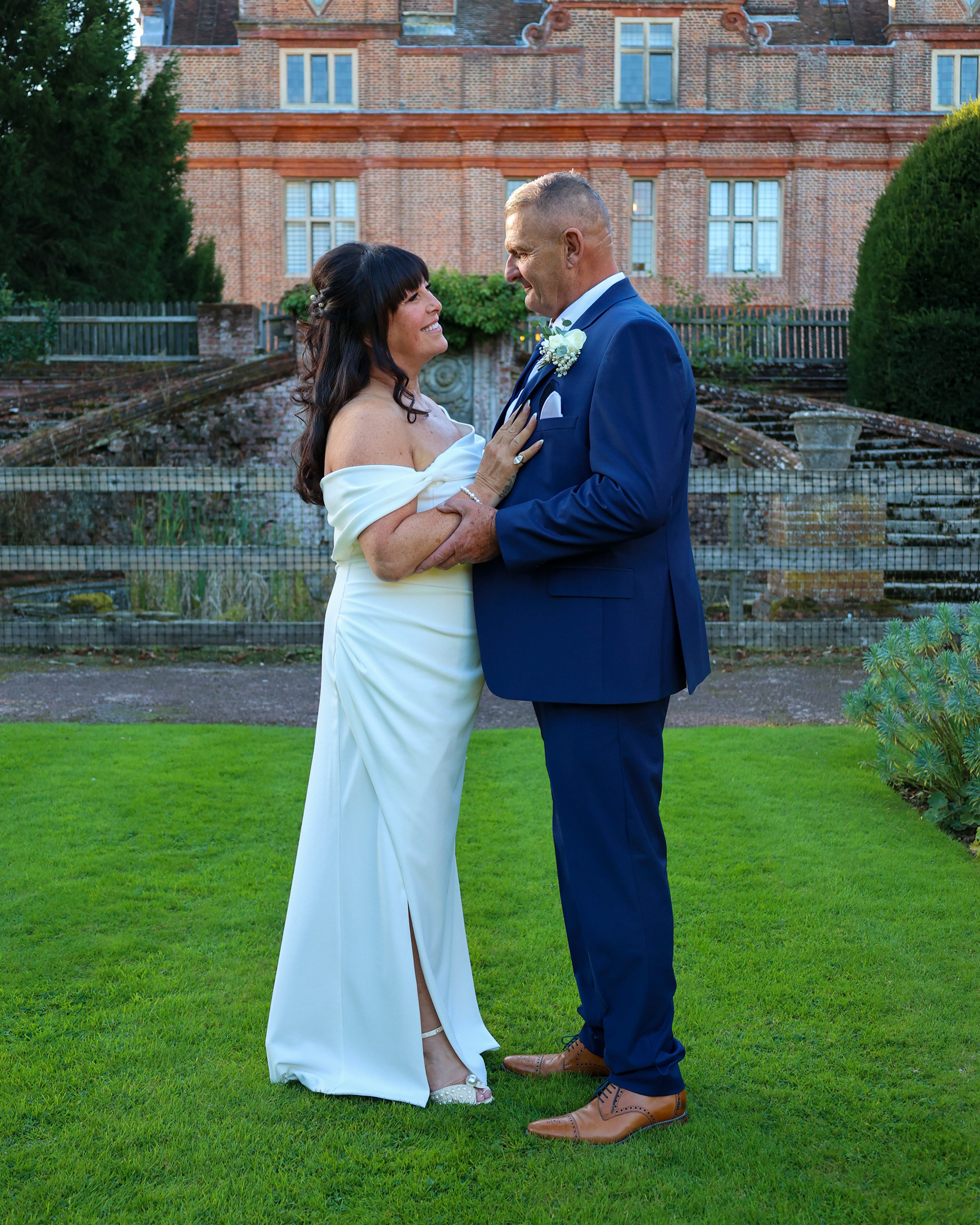 Couple enjoys a serene moment in the lush garden of a Canterbury wedding venue in Kent.