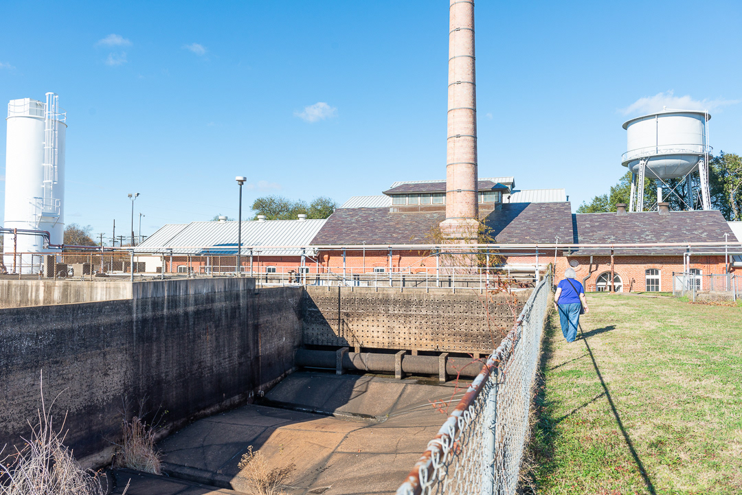 Settling tank with pumping station building in background