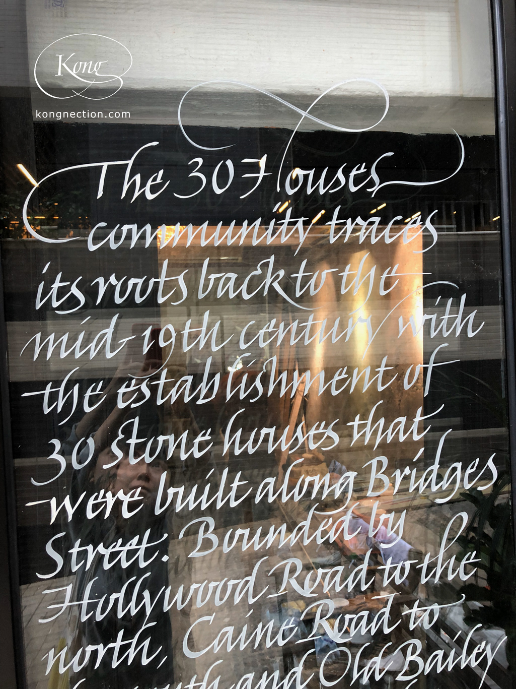 Writing the story of the '30 Houses Community' on glass doors for Chez Trente.