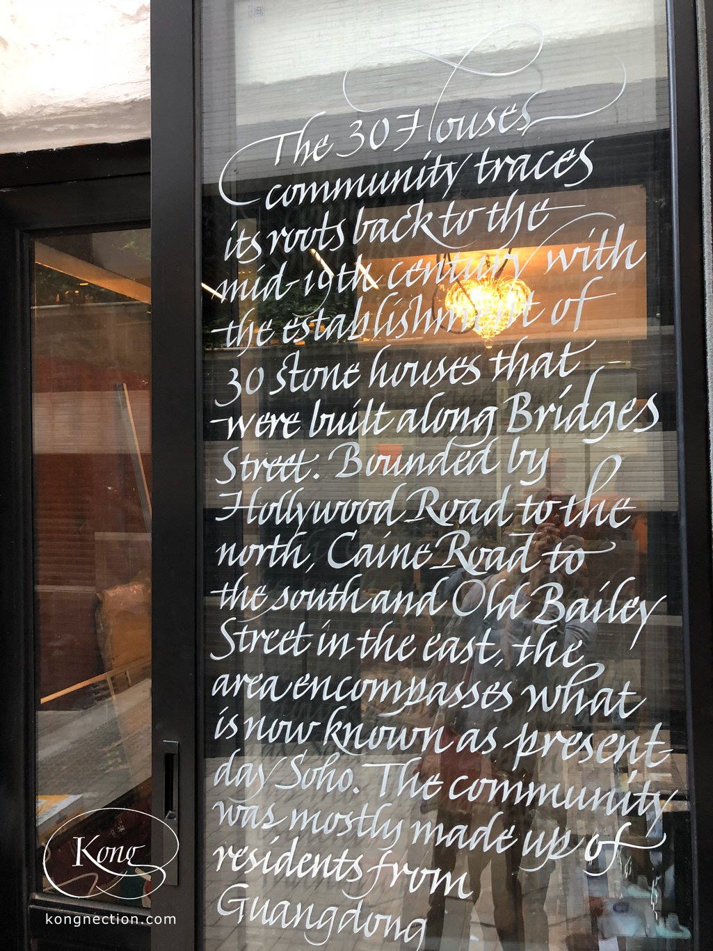 Writing the story of the '30 Houses Community' on glass doors for Chez Trente.