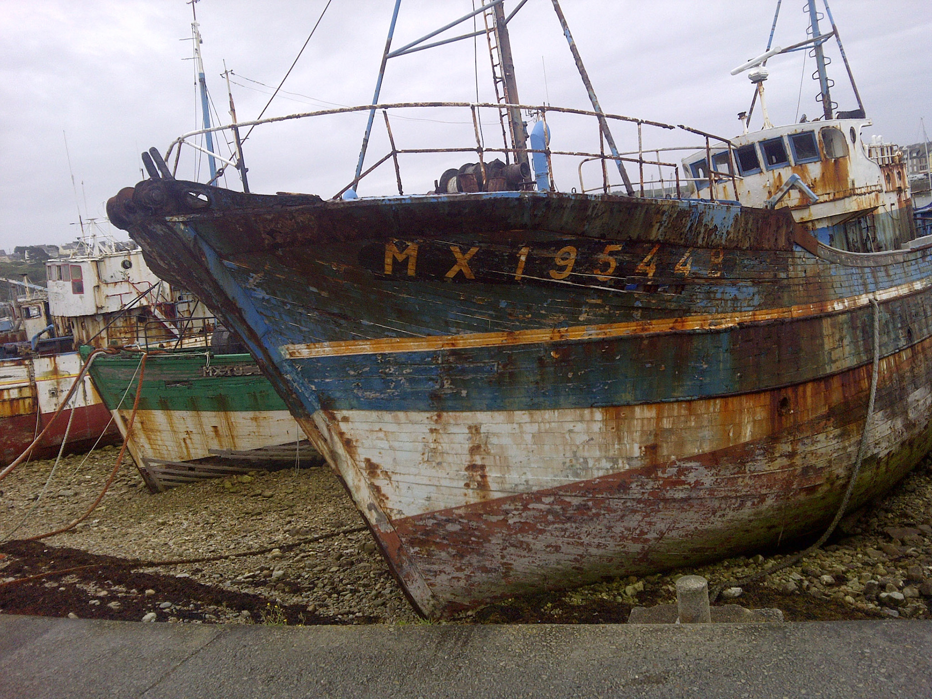 Retired fishing boats are dumped on the harbor's coast in Camaret-sur-Mer, a tradition in Brittany, France