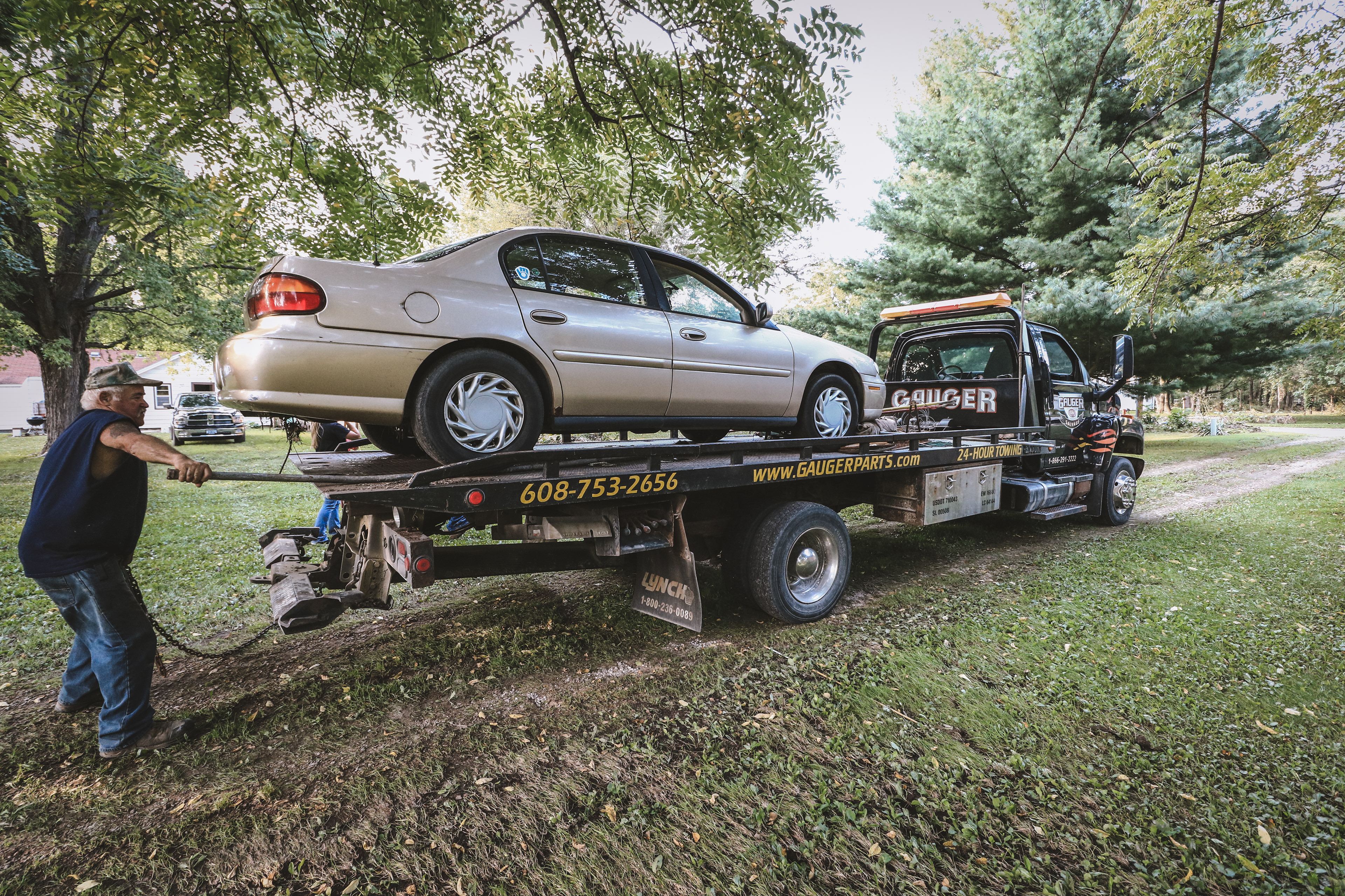 Bill Gauger tows a flooded car from the Travis home to be scrapped.