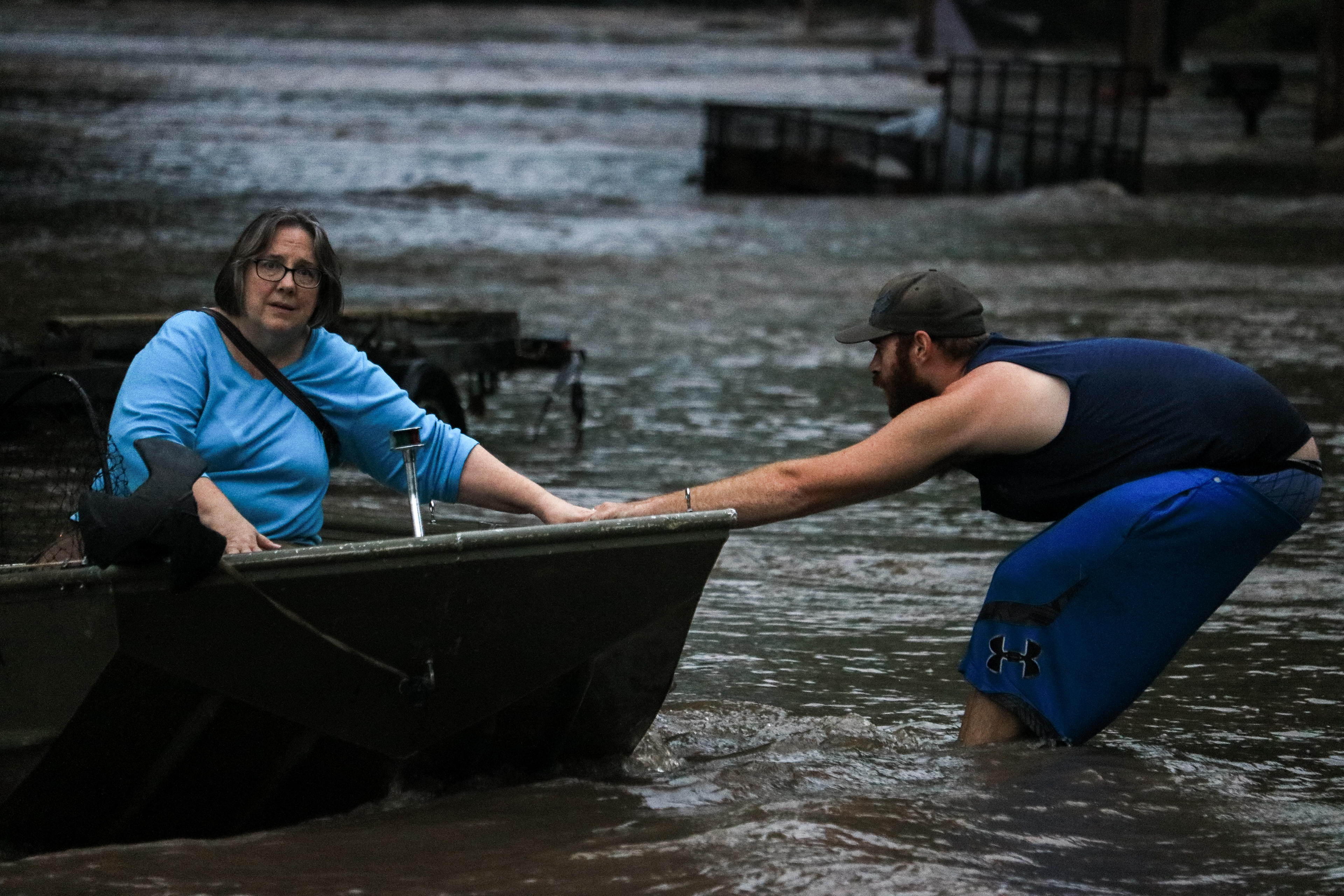 Craig Booth uses his boat to rescue his neighbor, Sue Vondra.