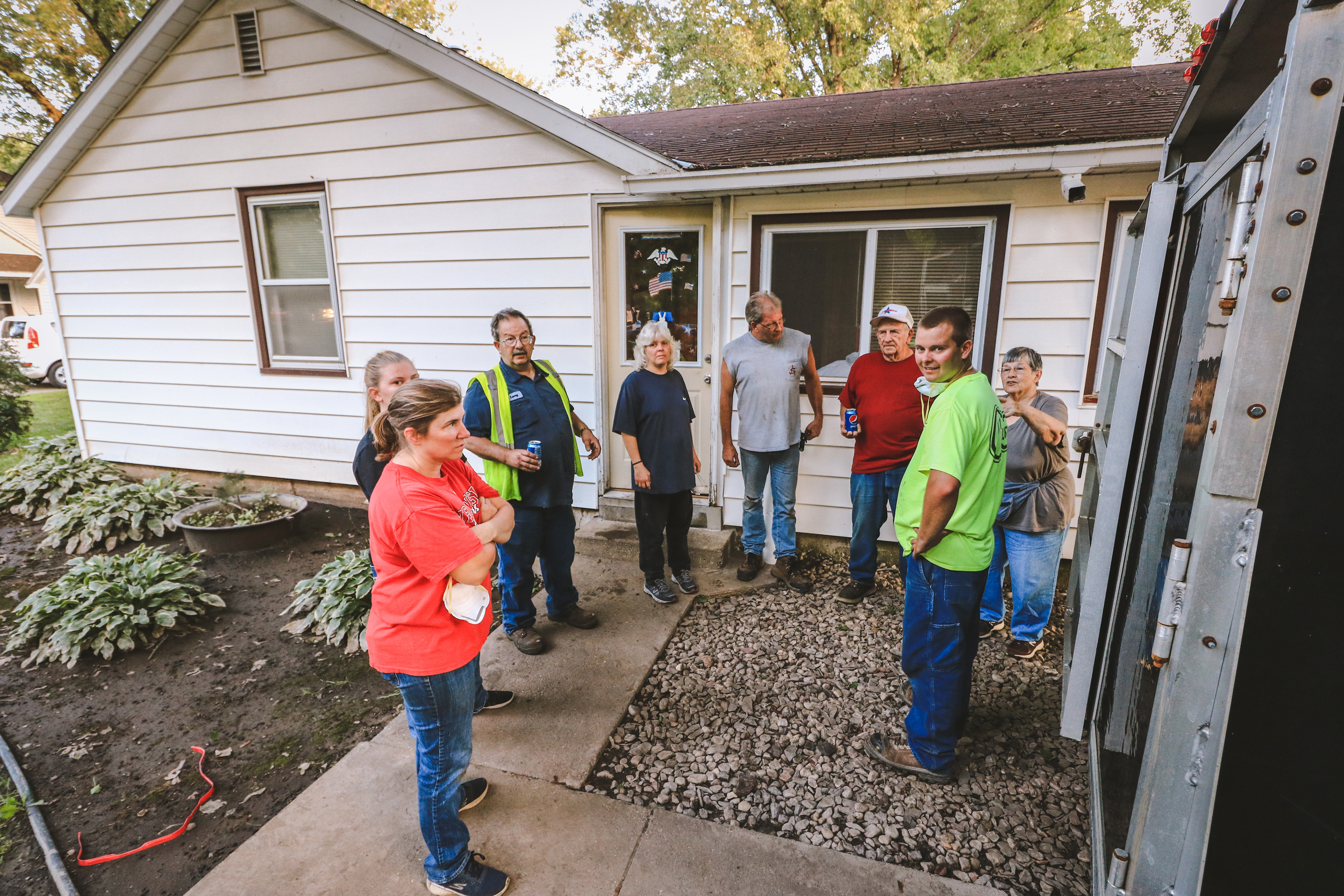 The Travis family takes a break after loading furniture and belongings into a trailer.