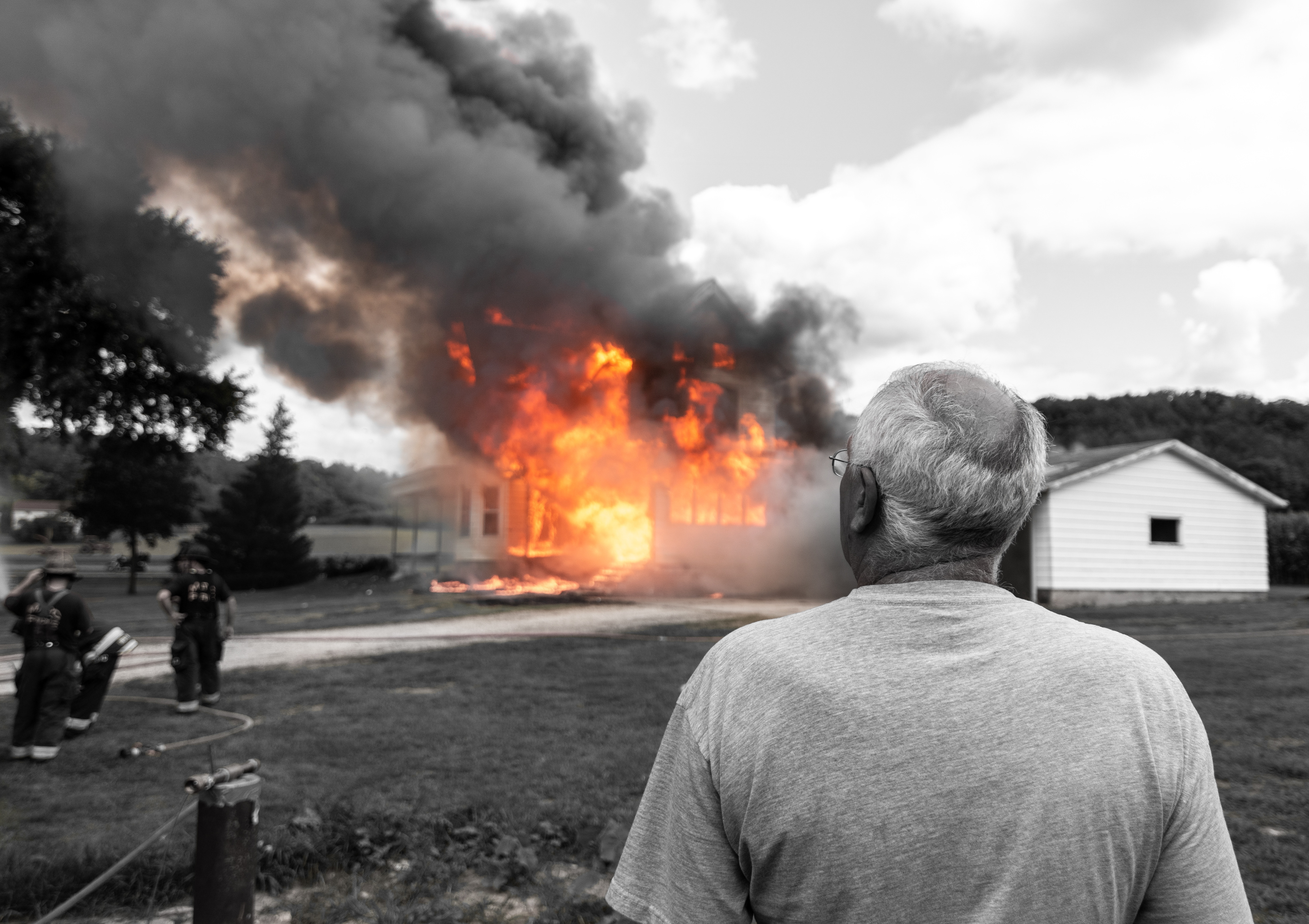 Ron Marx, owner of the home, stands in a moment of silence as he watches his old farmhouse engulf in flames.