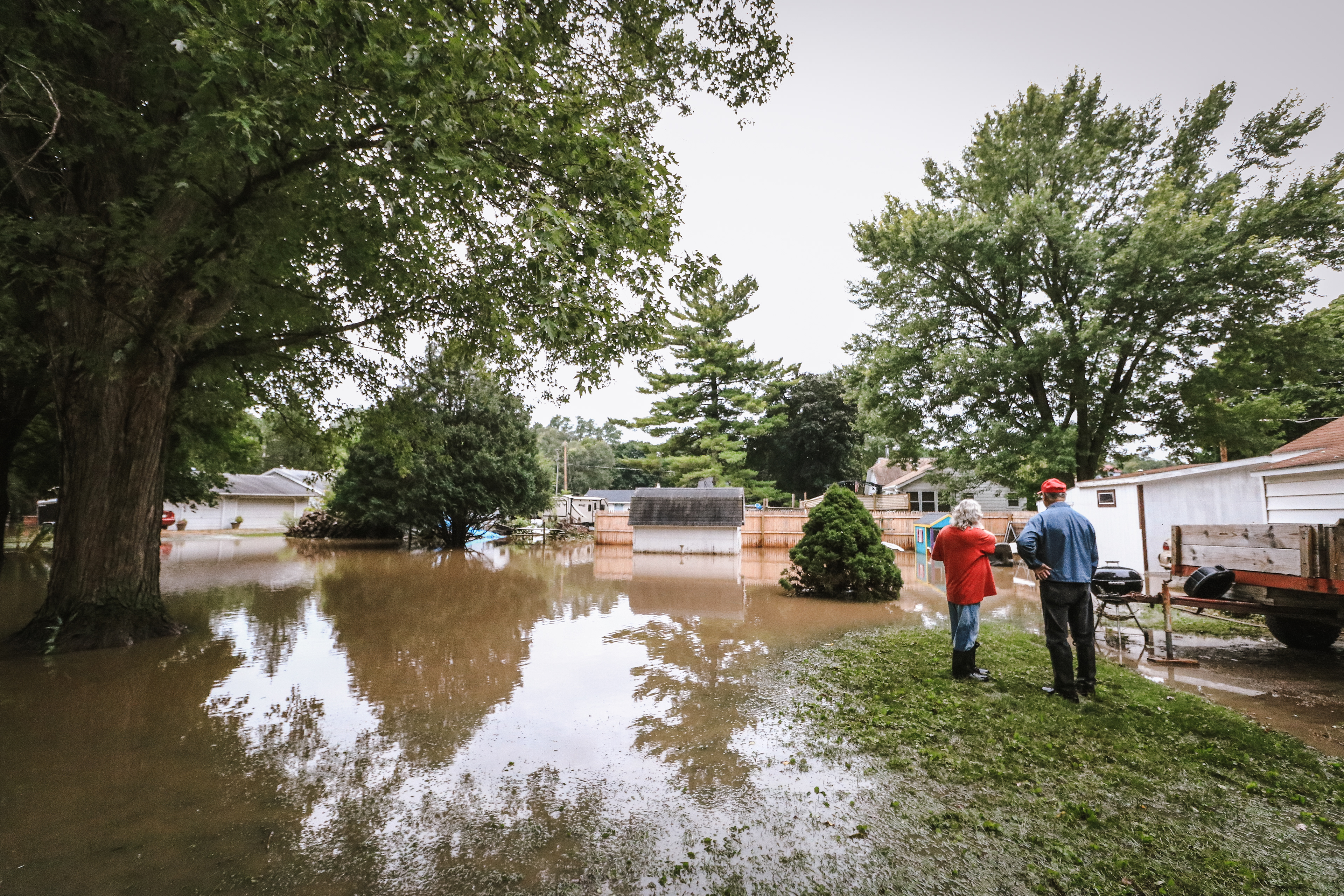 Teresa Travis inspects damage in her backyard with her father, Bob Dublin.
