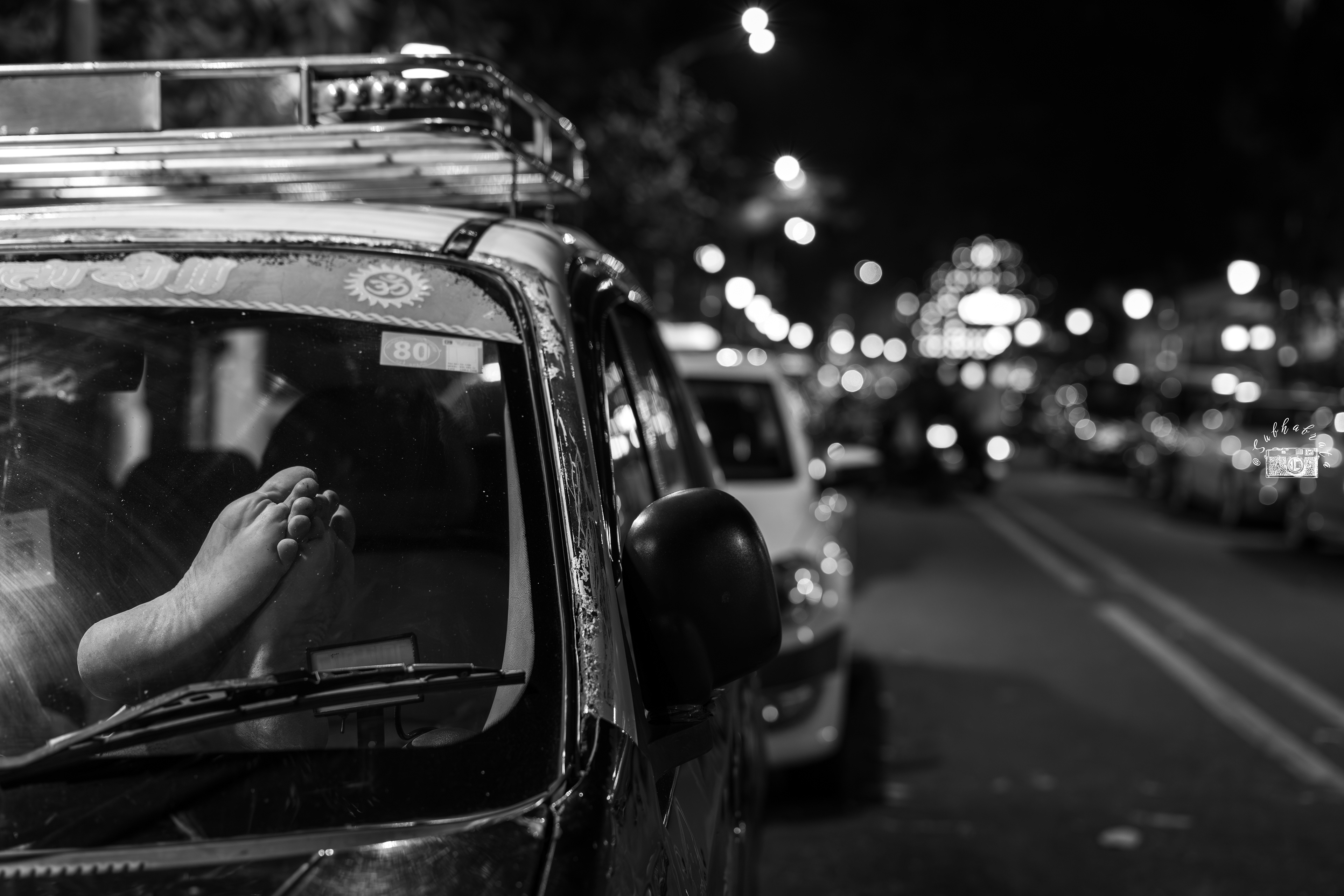 Moments of Pause:  A tourist cab driver takes a moment to rest inside his car—the iconic yellow taxi of Mumbai, now on the brink of extinction—while his passengers explore Colaba on foot.
