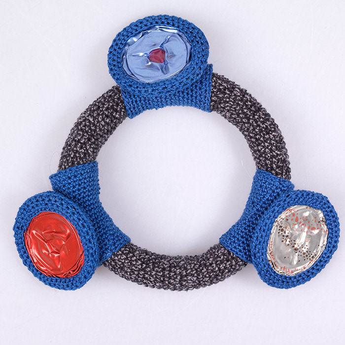 Gehäkelter Armreif in Schwarz/Grau mit drei beweglichen Elementen aus Kaffeekapseln, blau umhäkelt.