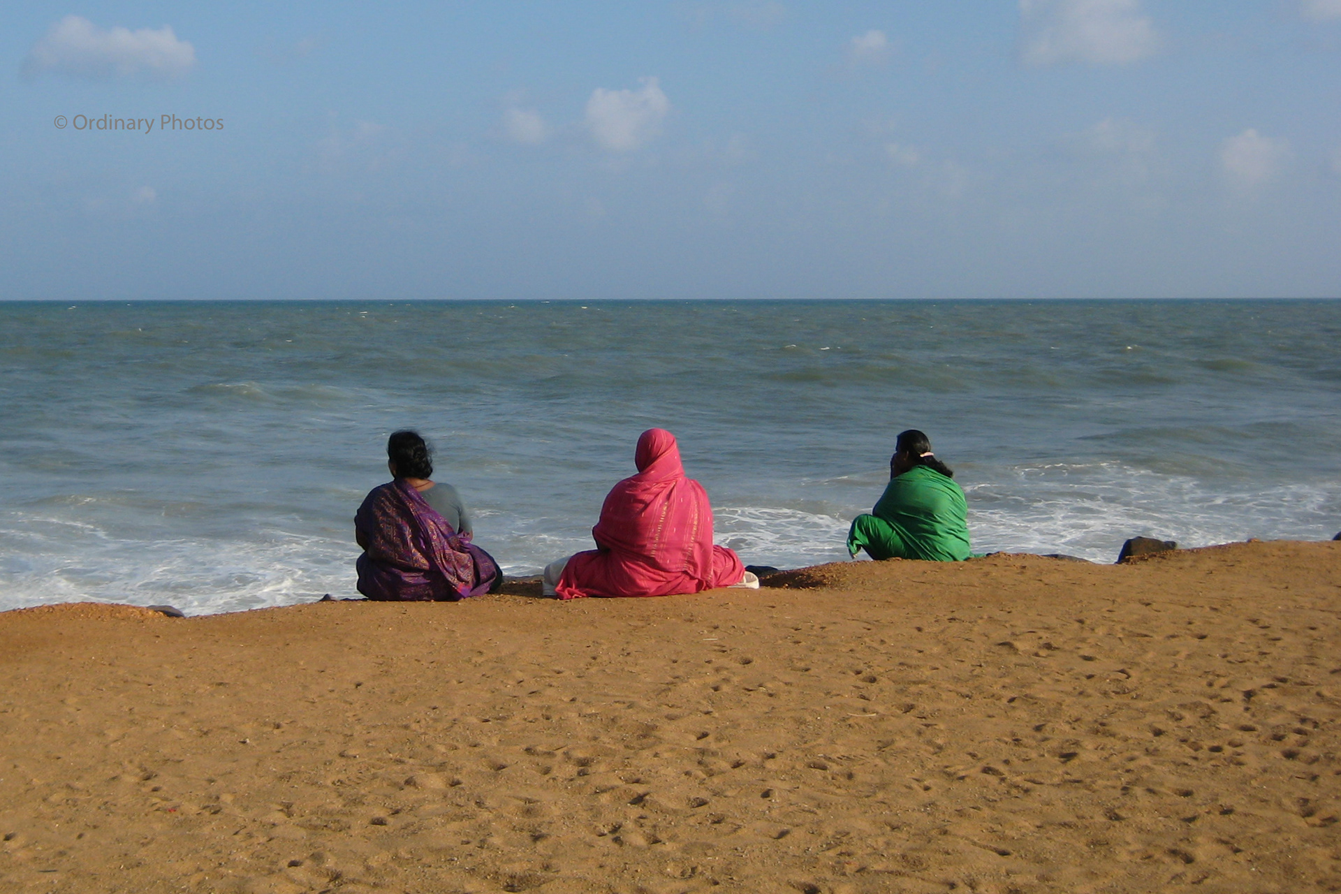 Colourful women watching the ocean in Pondicherry